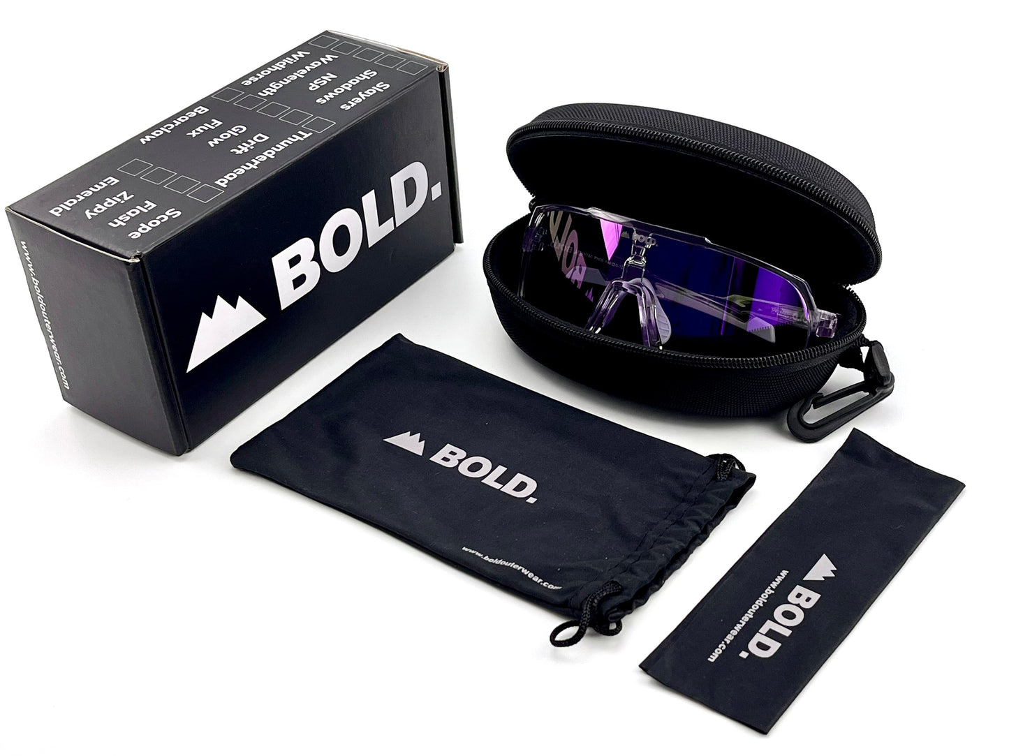 A black boldouterwear box, hard zip case with BOLD Slayers Photochromic Sunglasses (purple-tinted, oversized), drawstring pouch, and cleaning cloth—all with the boldouterwear logo—are neatly displayed on a white background.