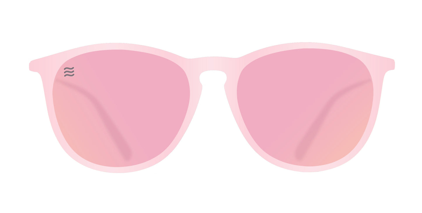 Illustration of Neven Eyewear's Dreamy pink polarized sunglasses featuring rounded, glossy frames and tinted pink lenses with a wavy logo on the upper left lens, set against a plain white background.