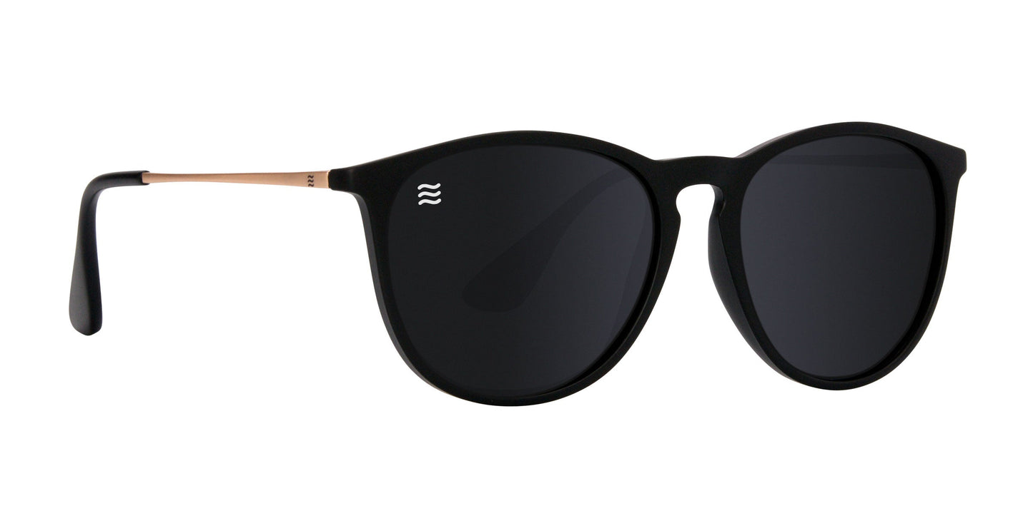 Goldie Lux by Neven Eyewear features sleek matte black and gold TR90 frames, round dark polarized UV400 lenses, thin metallic arms, and a small white wave logo for a modern, stylish look.