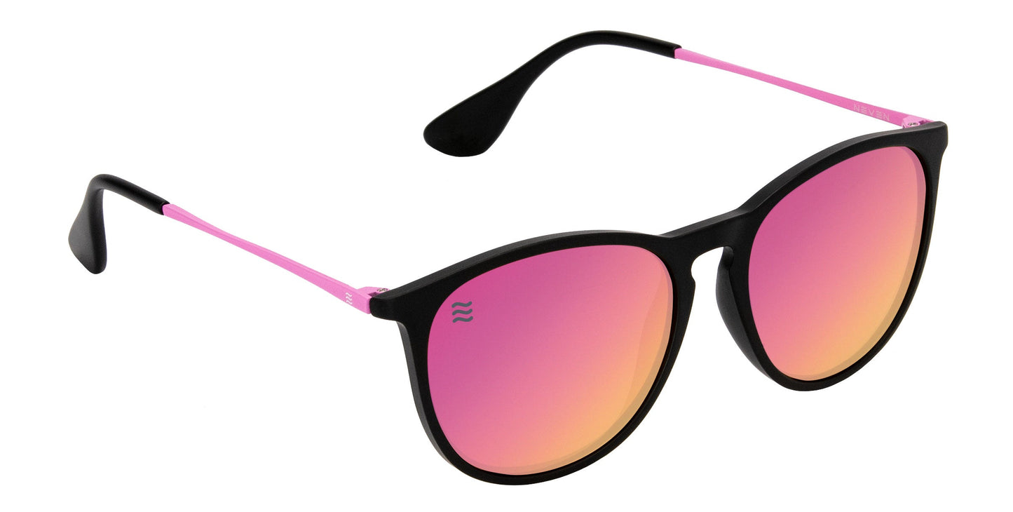 The Neven Eyewear Quinn sunglasses feature round, oversized TR90 frames with a black front and pink stainless steel arms. The polarized pink-orange mirrored lenses and curved earpieces ensure clarity and comfort.