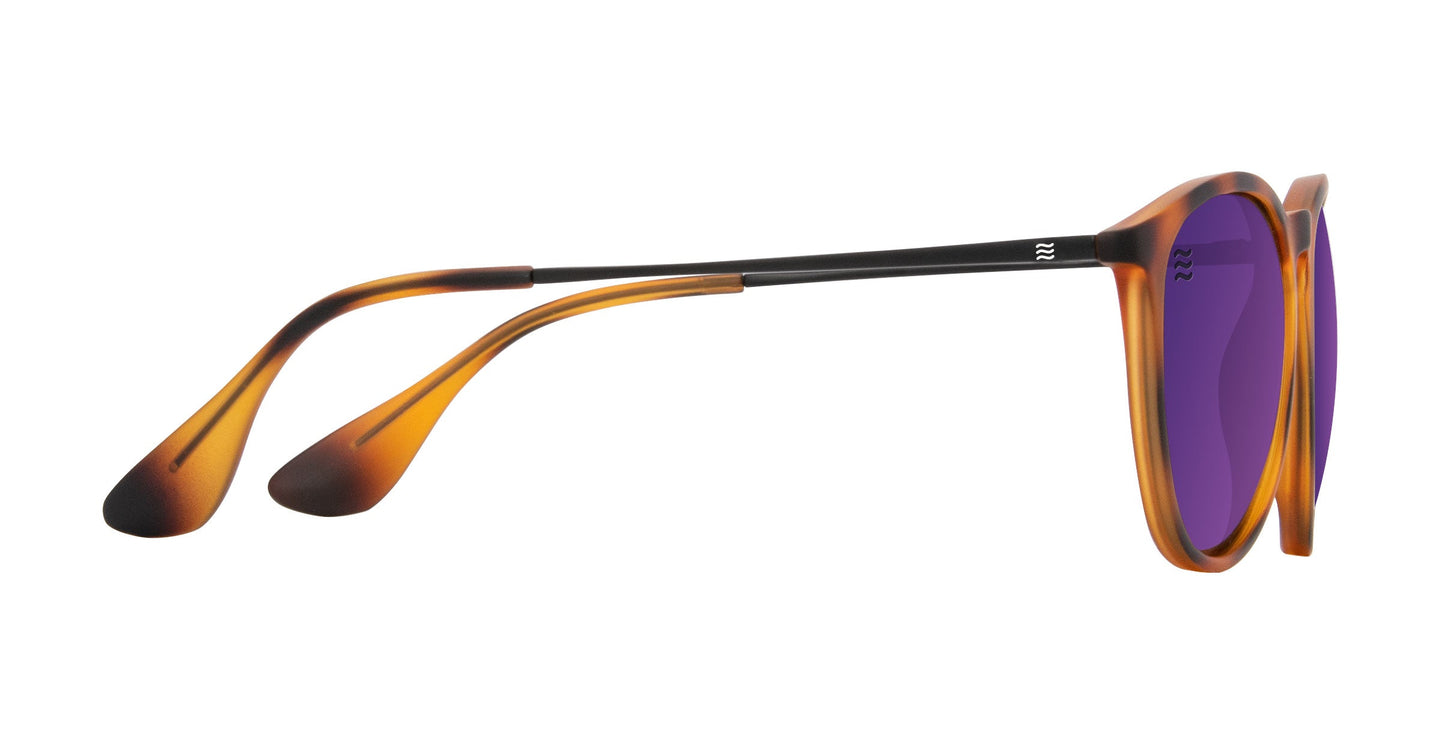 Side view of Neven Eyewear’s Stella sunglasses featuring round, purple-tinted polarized lenses, TR90 frames, thin black metal arms, wide curved brown tortoiseshell plastic tips with rounded ends for comfort, and UV400 protection.