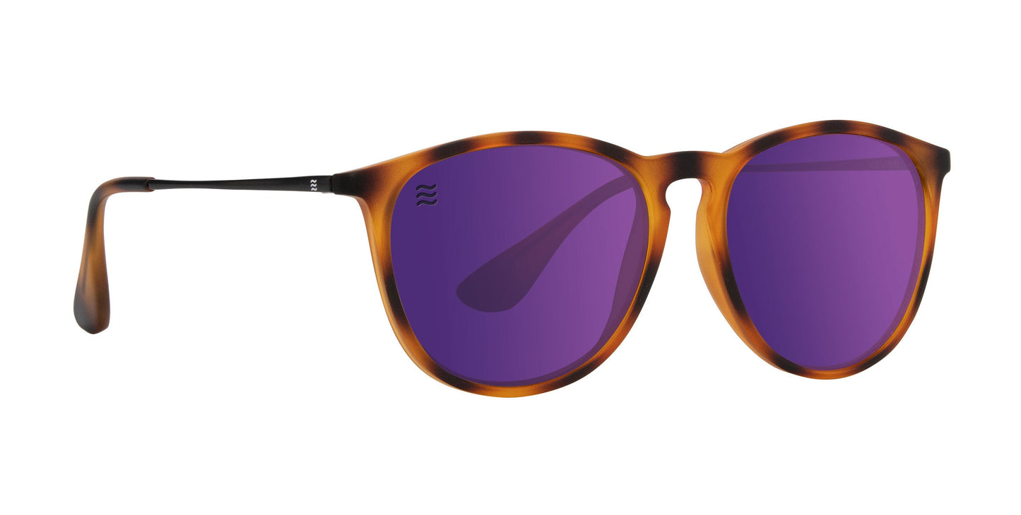 The Stella sunglasses by Neven Eyewear feature a round tortoiseshell TR90 frame, purple-tinted polarized lenses with UV400 protection, wave logo on the lens, thin temples, and curved ends. Shown on a plain white background.