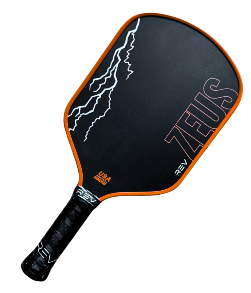 The ZEUS Pickleball Paddle by REV Pickleball features a black base with an orange edge, white lightning bolts on the left, bold orange “ZEUS” on the right, and a REV-labeled black handle. Made from T700 Raw Carbon Fiber.