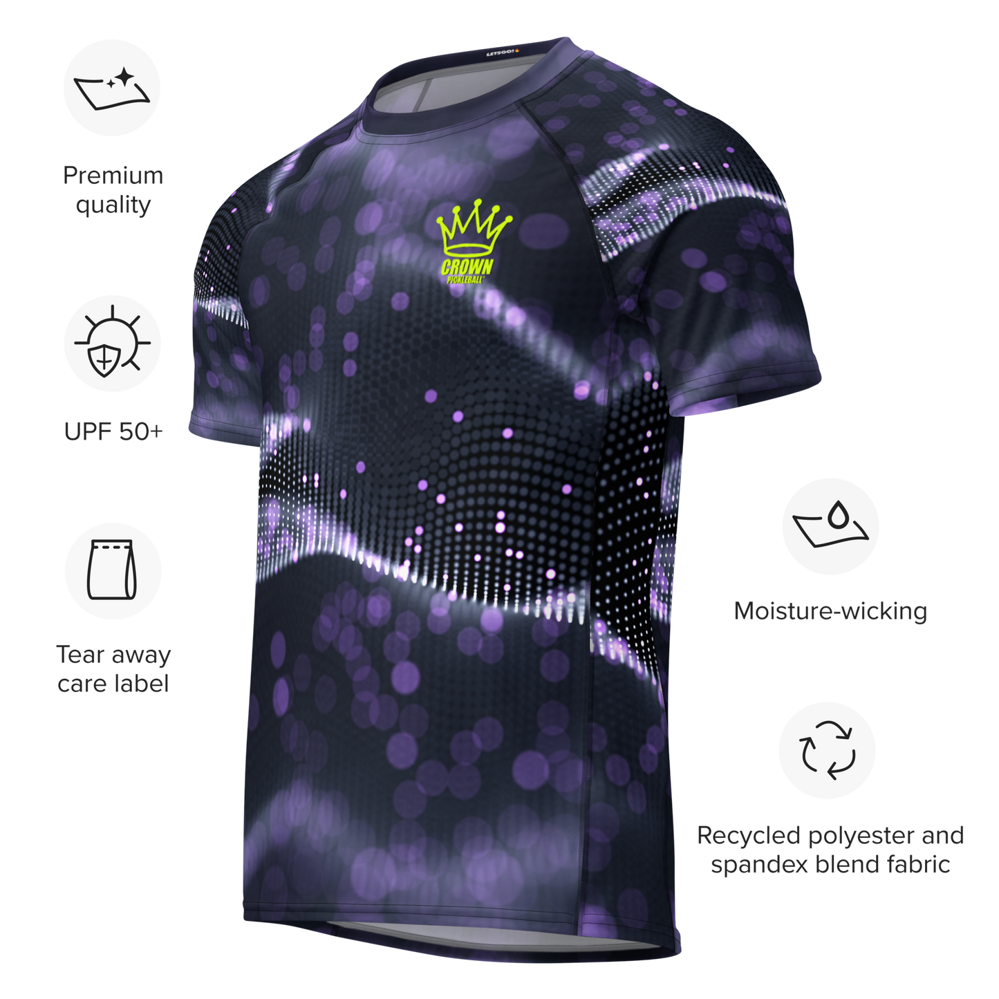 The CROWN PICKLEBALL - Men's Tourney Shirt (Purple) by Crown Pickleball is a dark athletic tee with a purple and white abstract dotted print, yellow crown logo, and CROWN text. It features UPF 50+ protection, moisture-wicking recycled fabric, and a tear-away label.