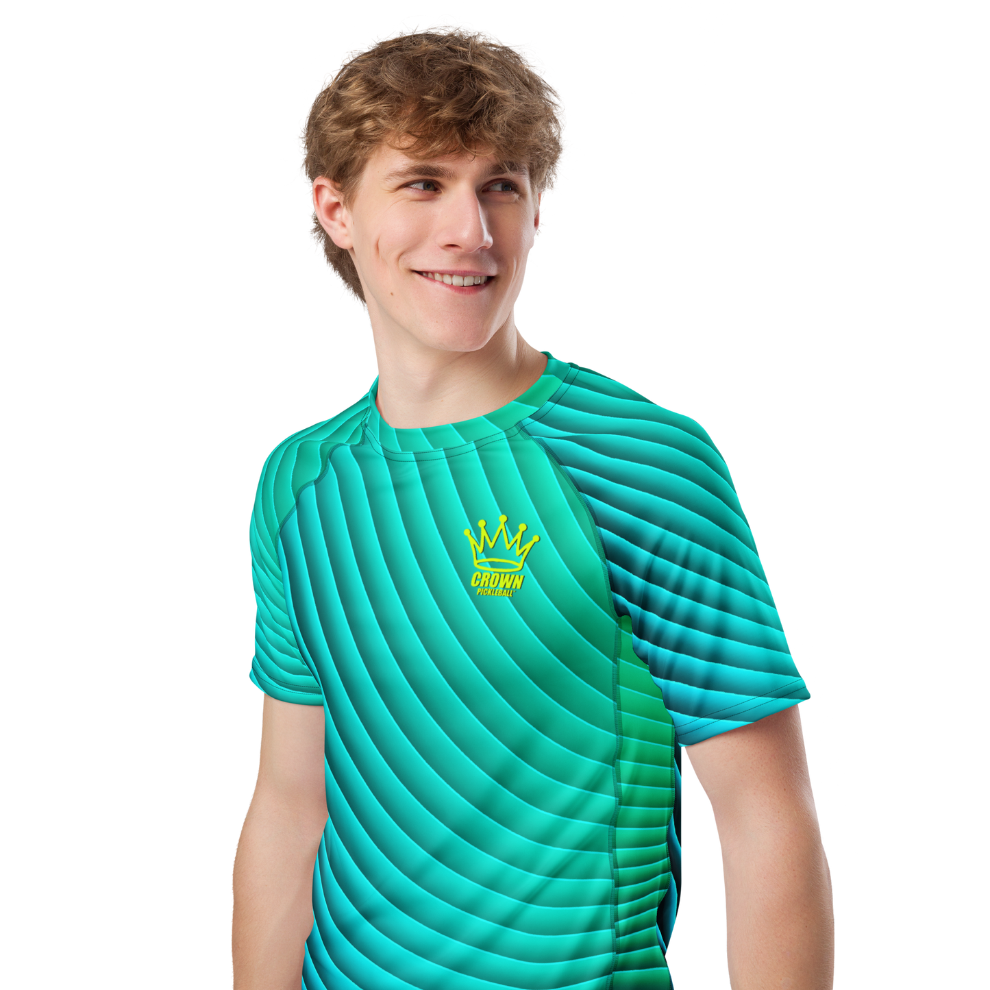 A young man with light brown hair smiles in a Crown Pickleball men's Tourney Shirt (Turquoise), featuring vibrant green and blue stripes, a yellow crown logo, and the word "CROWN" on the left chest, set against a plain white background.