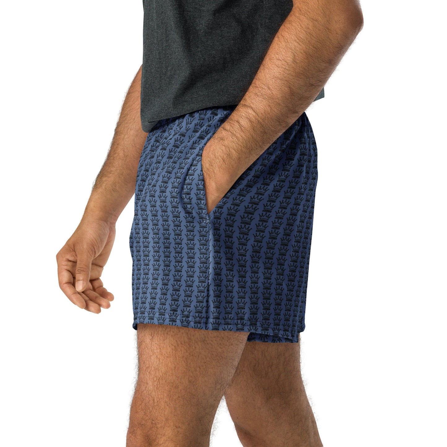 A person wears Crown Pickleball's CROWN PICKLEBALL - Logo Pattern Short (Wedgewood), featuring a blue pattern, paired with a dark grey tee. The recycled polyester fabric offers moisture-wicking comfort. Image shows only the torso and legs on white background.
