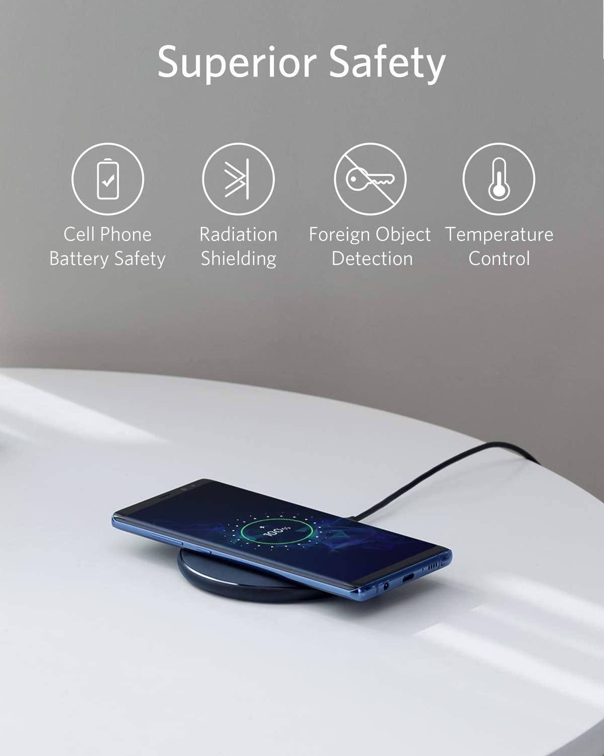 A smartphone charges wirelessly on the Anker 313 Wireless Charger (Pad) by Anker, shown on a white surface. Above are icons and text highlighting Superior Safety: Cell Phone Battery Safety, Radiation Shielding, Foreign Object Detection, and Temperature Control.