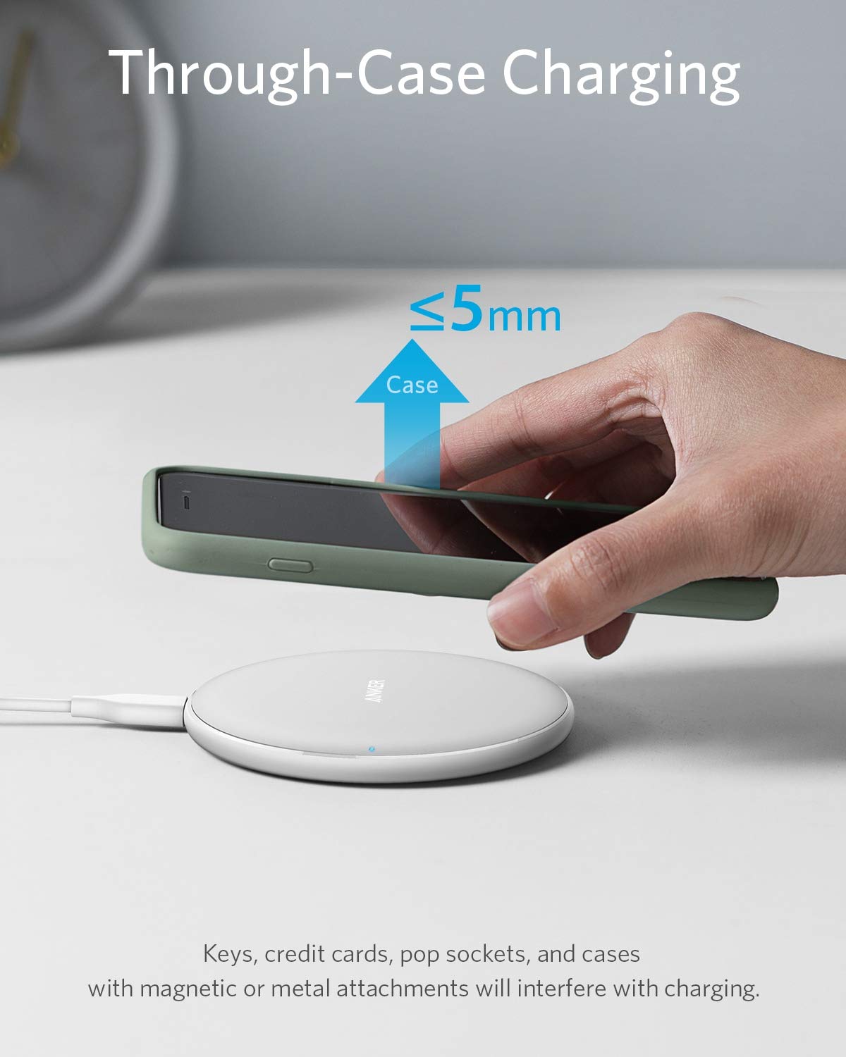 A hand holds a smartphone in a slim green case above the Anker 313 Wireless Charger (Pad) by Anker, with an arrow showing ≤5mm thickness. Text reads "Through-Case Charging." Note: Magnetic or metal items will interfere with charging.