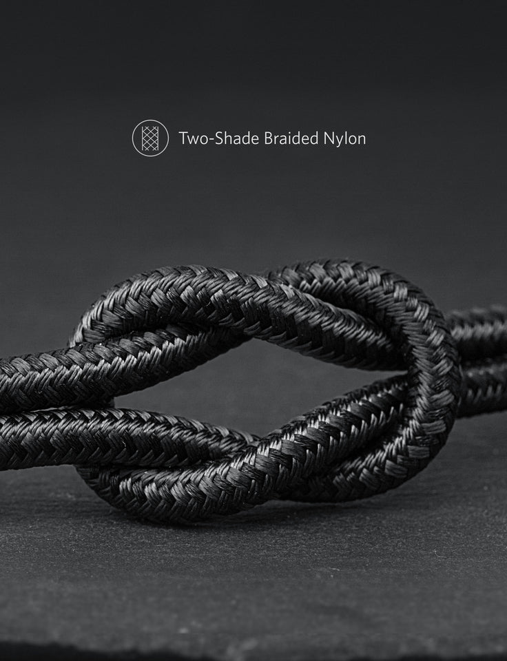 A close-up of a neatly tied knot in a black, two-tone braided nylon rope on a dark surface. Text above reads: Anker 551 USB-A to Lightning Cable (3 ft / 6 ft / 10 ft), MFi certified, with a geometric rope icon.