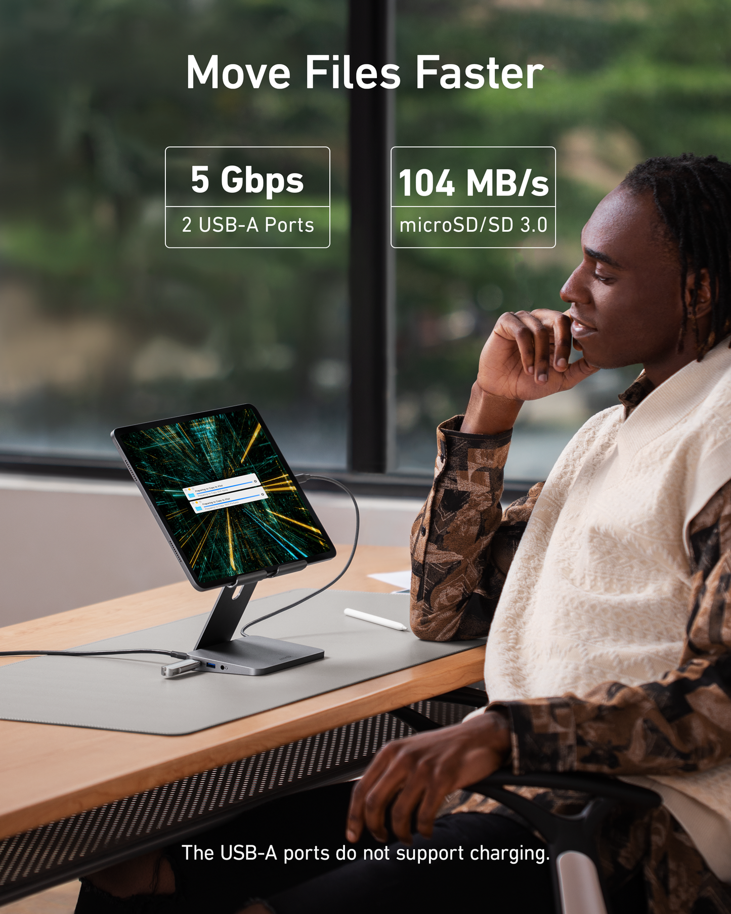 A person uses the Anker 551 USB-C Hub (8-in-1, Tablet Stand) at their desk, moving files faster with 5 Gbps and 2 USB-A ports. Ideal as an iPad Pro hub; note: USB-A ports do not support charging.