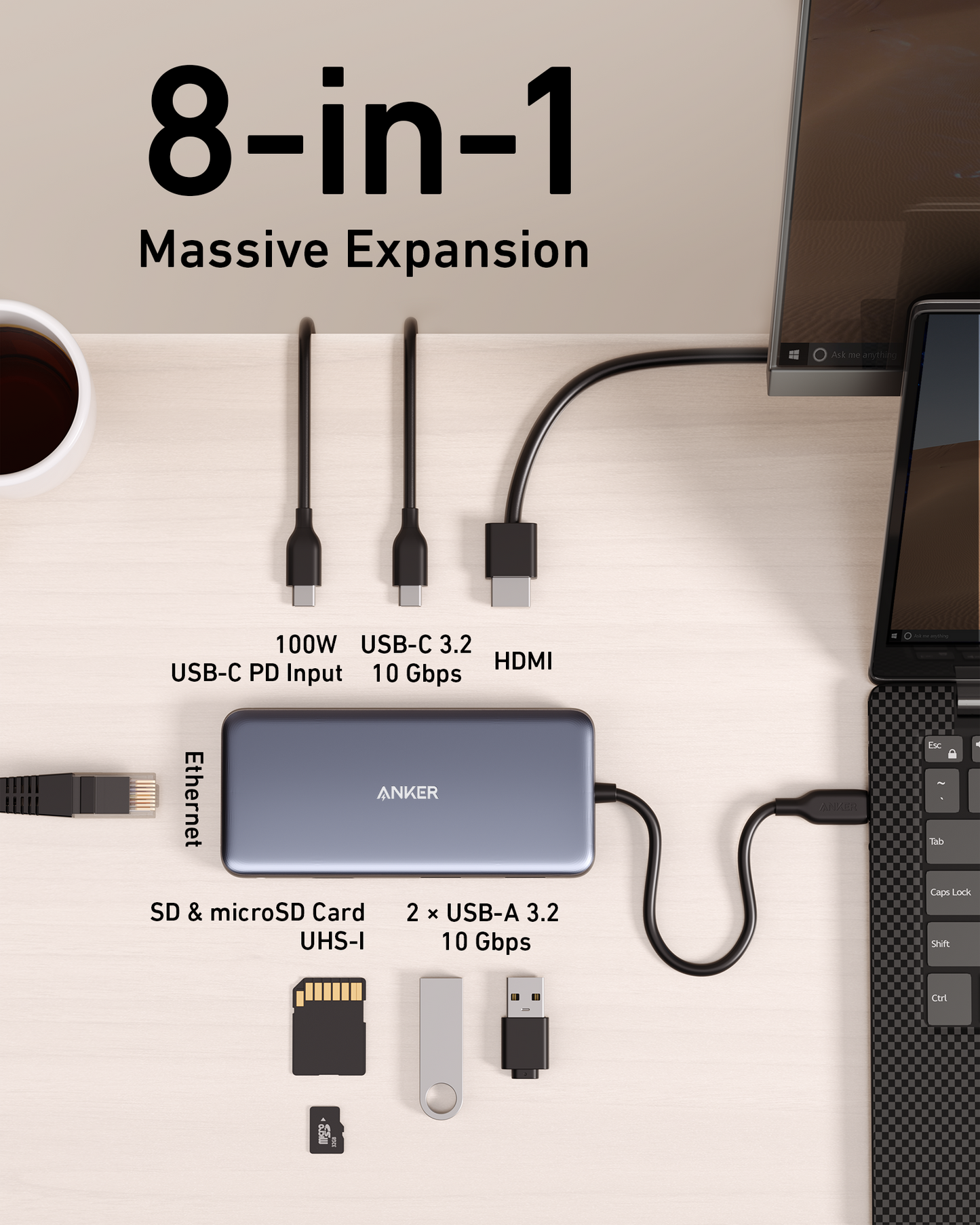 An Anker 555 USB-C Hub (8-in-1) rests on a wooden desk, connected to a laptop. It offers Power Delivery, HDMI, Ethernet, SD/microSD slots, and more. A coffee cup and USB drives are also on the desk.