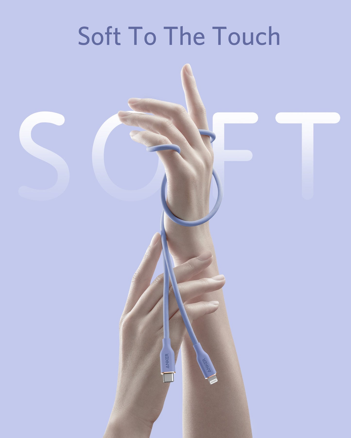 Against a light lavender background, two fair-skinned hands are pictured with the Anker 641 USB-C to Lightning Cable (Flow, 3 ft Silicone) in soft blue gently wrapped around one wrist. Text above reads Soft To The Touch; large, faded letters spell SOFT.