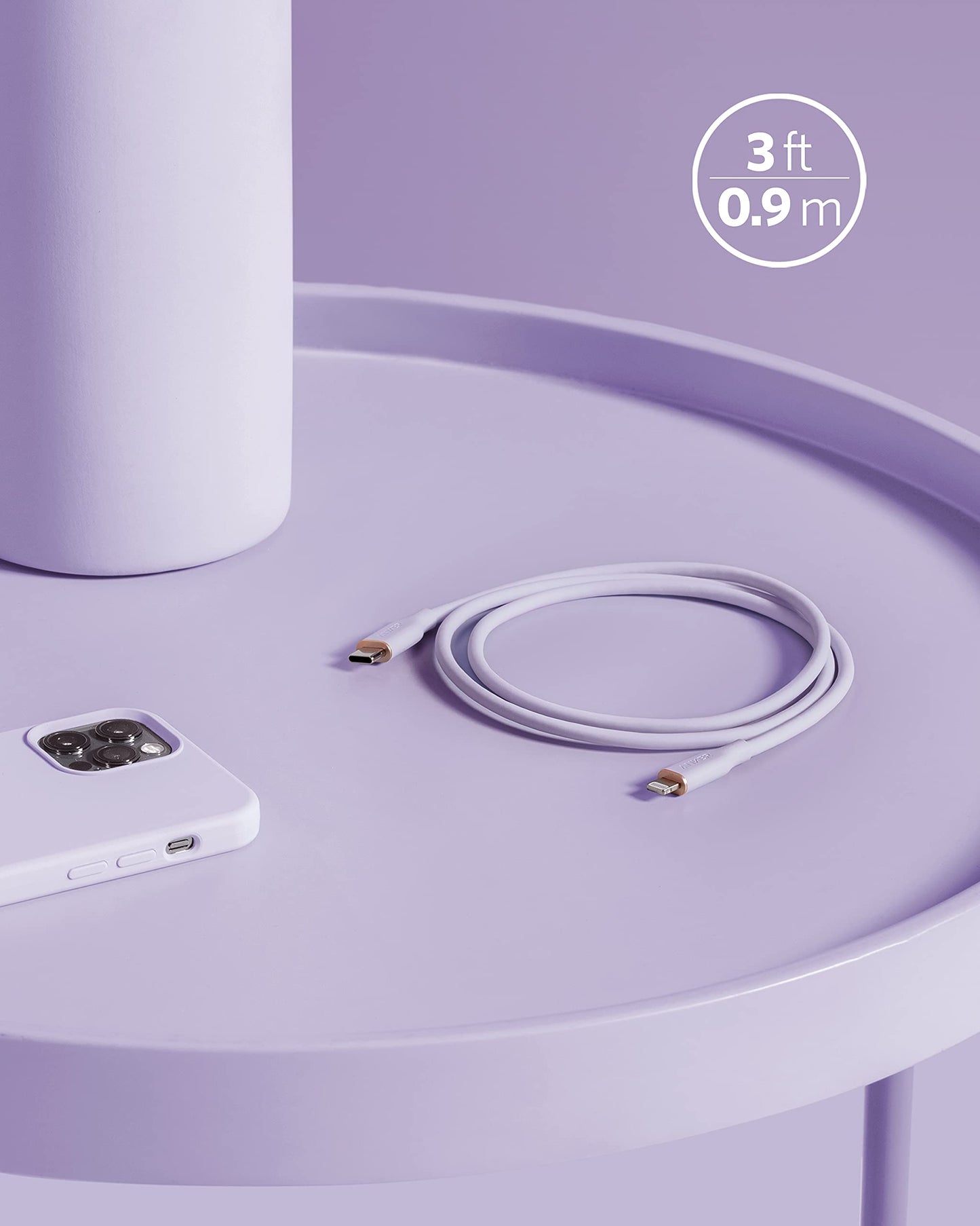 An Anker 641 USB-C to Lightning Cable (Flow, Silicone) in white is coiled on a round light purple table beside a white smartphone and a white cylinder. A graphic highlights its 3 ft (0.9 m) length in this minimal, pastel scene.