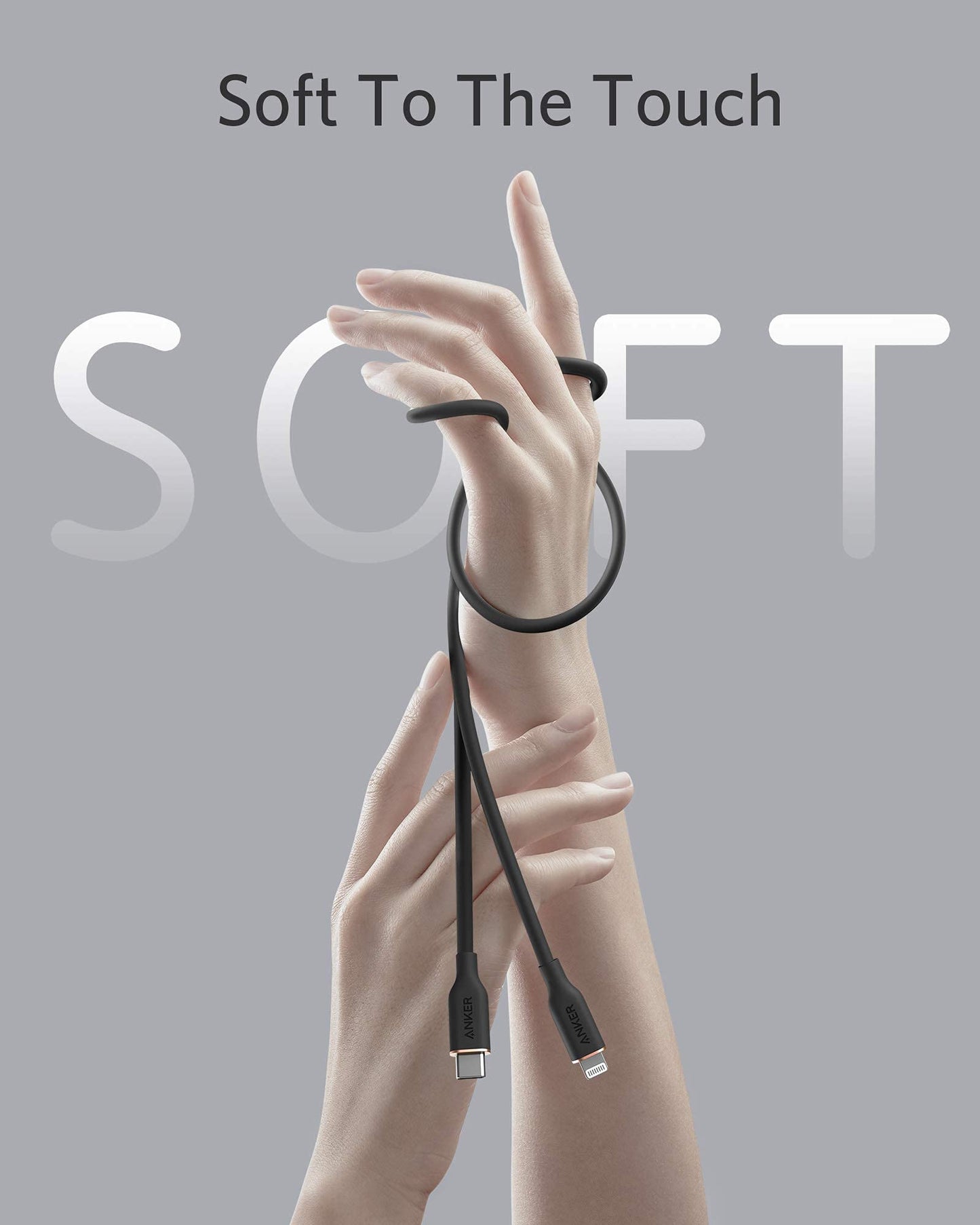 Two graceful hands rise against a gray backdrop, one wrapped with the Anker 641 USB-C to Lightning Cable (Flow, Silicone). “Soft To The Touch” appears above, with large faded “SOFT” lettering behind the hands. Brand: Anker.