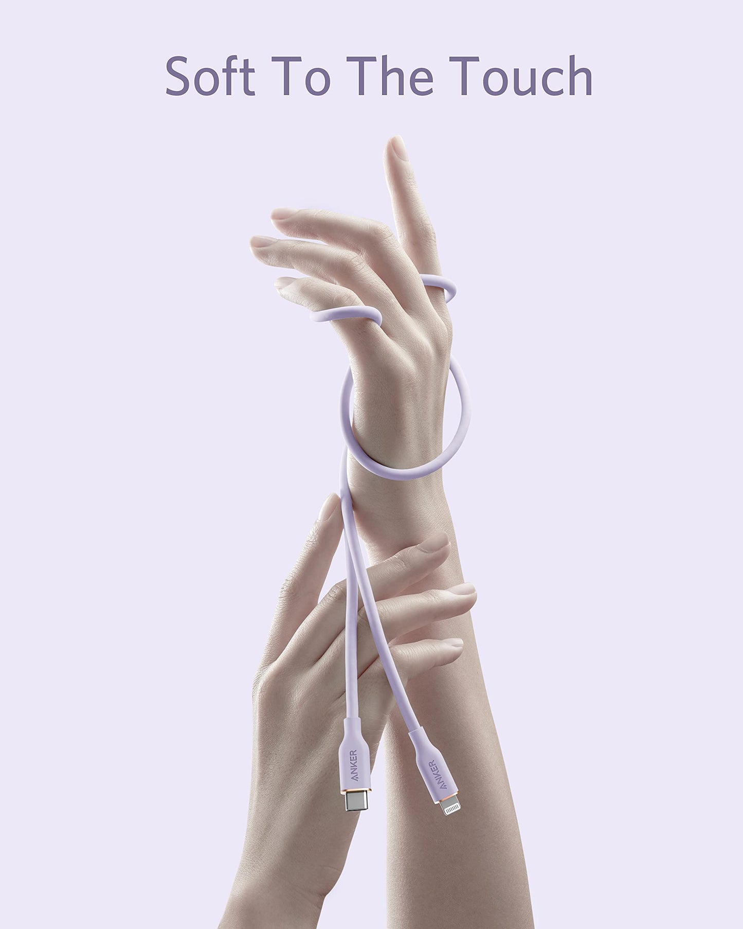 A lavender Anker 641 USB-C to Lightning Cable (Flow, Silicone) is loosely coiled around graceful hands on a pale lavender background. Above, the text "Soft To The Touch" highlights its smooth texture and gentle look.