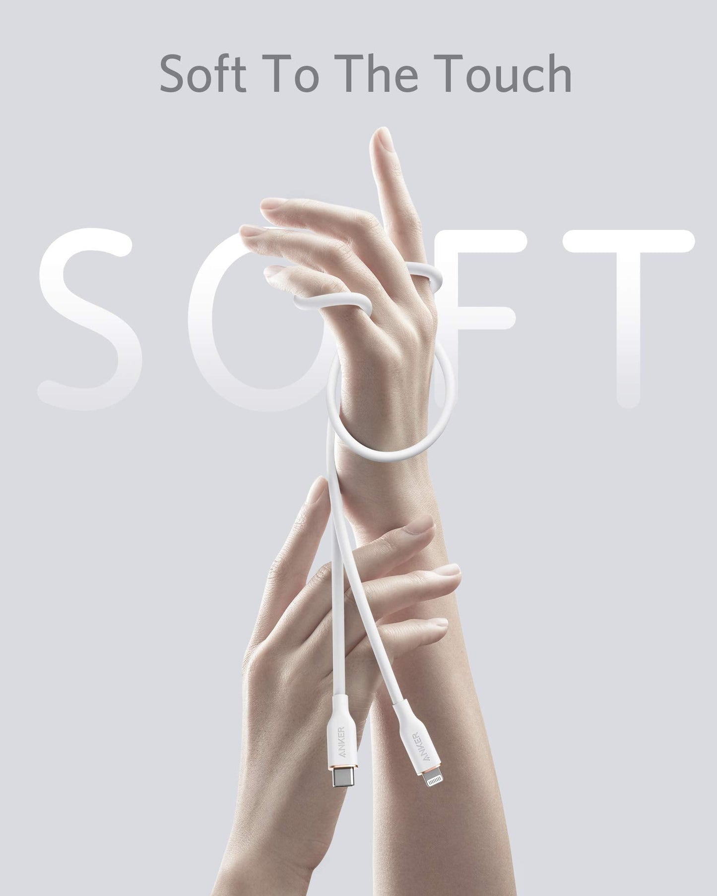 Two elegant hands appear on a light gray background, one gently holding the Anker 641 USB-C to Lightning Cable (Flow, Silicone), its white silicone design looping softly around the other wrist. Above, bold text reads Soft To The Touch with "SOFT" highlighted behind.