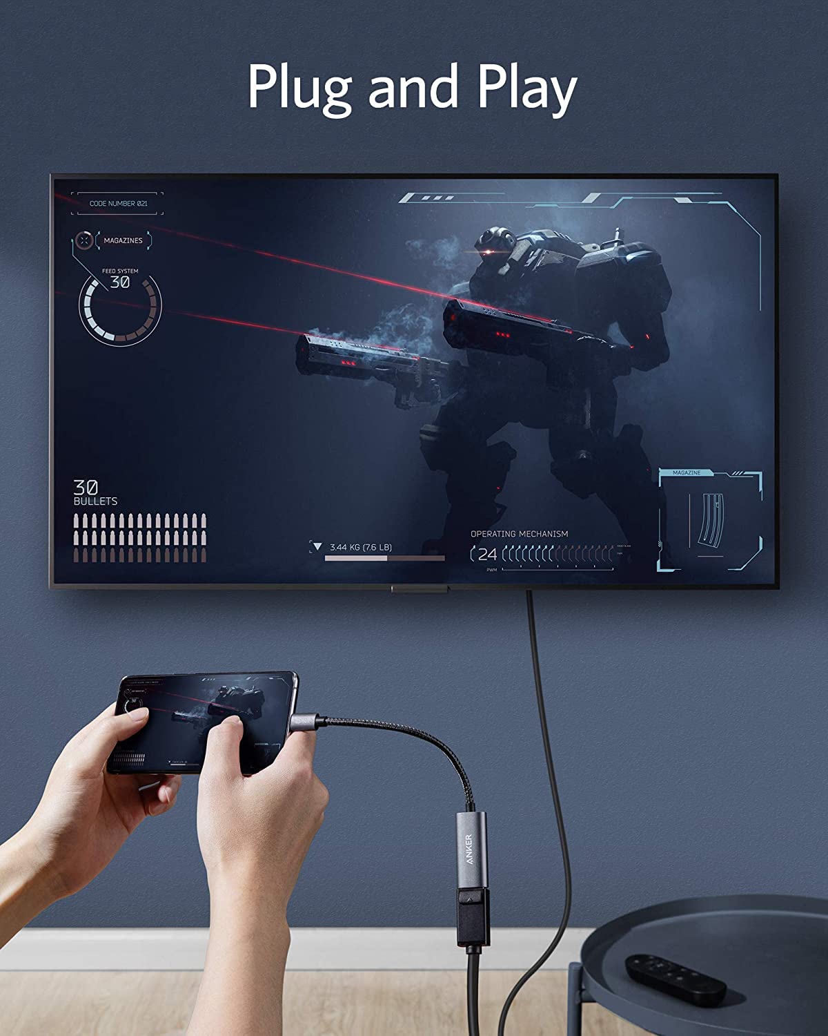 Someone connects a smartphone to a wall-mounted TV using the Anker <b>PowerExpand</b> USB-C to DisplayPort Adapter. The TV shows a futuristic robot soldier game with "Plug and Play" above. A remote control lies on a nearby round table.