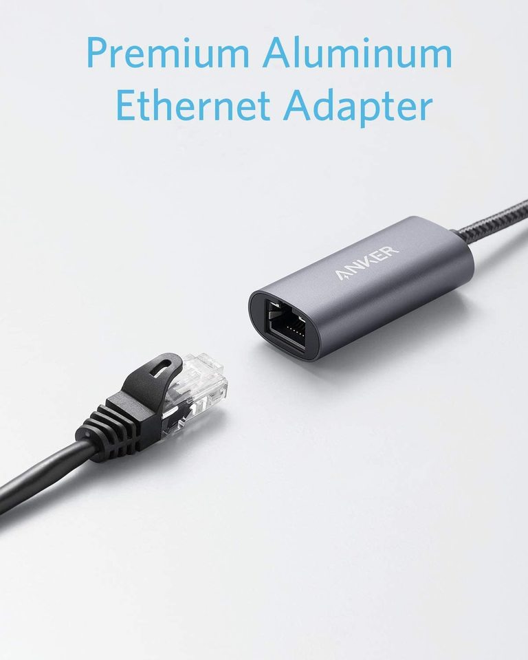 The Anker <b>PowerExpand</b> USB-C to Gigabit Ethernet Adapter rests on a light gray surface, an Ethernet cable nearby. Above, blue text says "Premium Aluminum Ethernet Adapter," highlighting its portable and sleek design.
