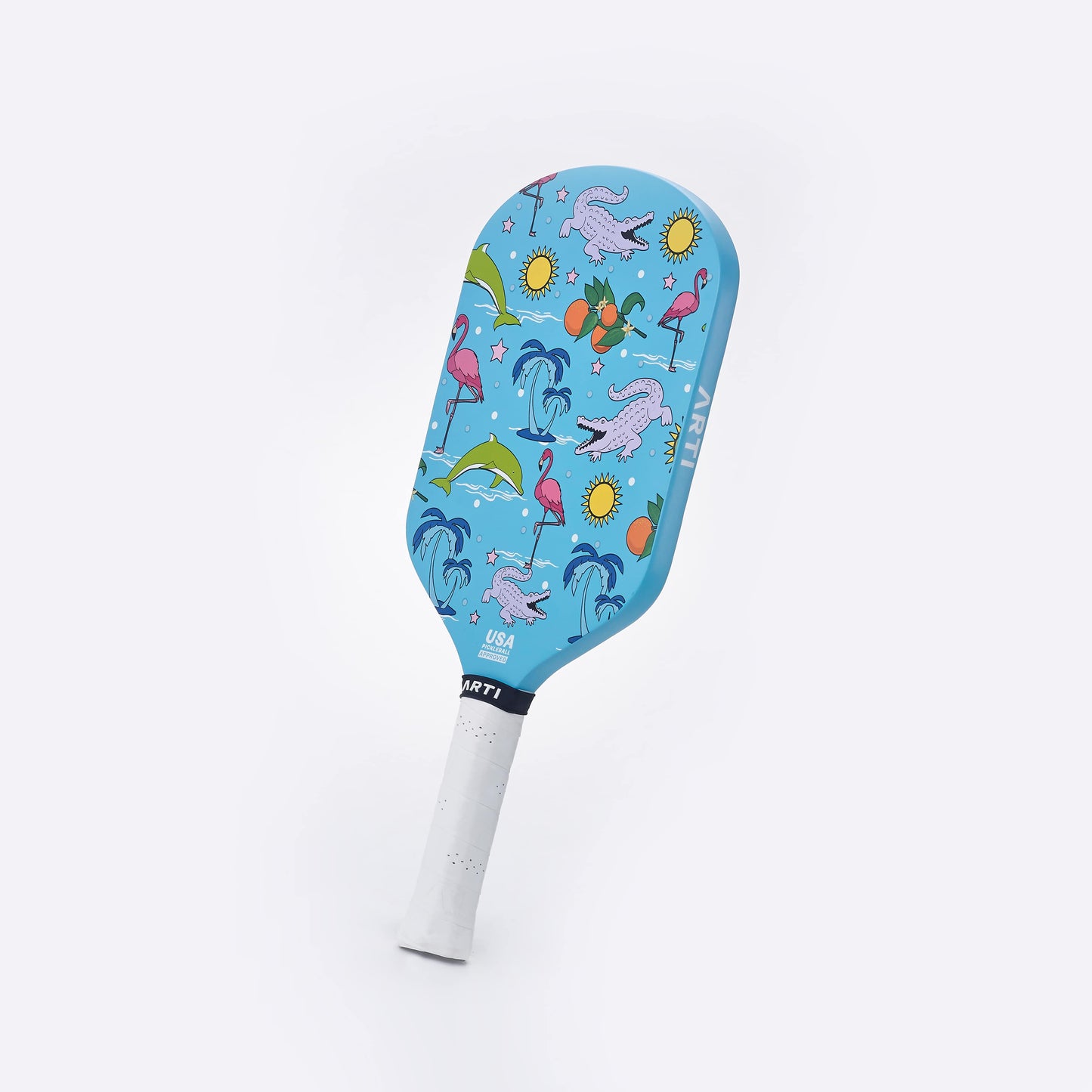 The ARTI Carbon Fiber "FLORIDA" Paddle features playful illustrations of purple alligators, pink flamingos, palm trees, oranges, green hills, and yellow suns on a blue face. Made by ARTI with T700 carbon fiber and a white grip; “USA” and “AMPT” printed near the bottom.