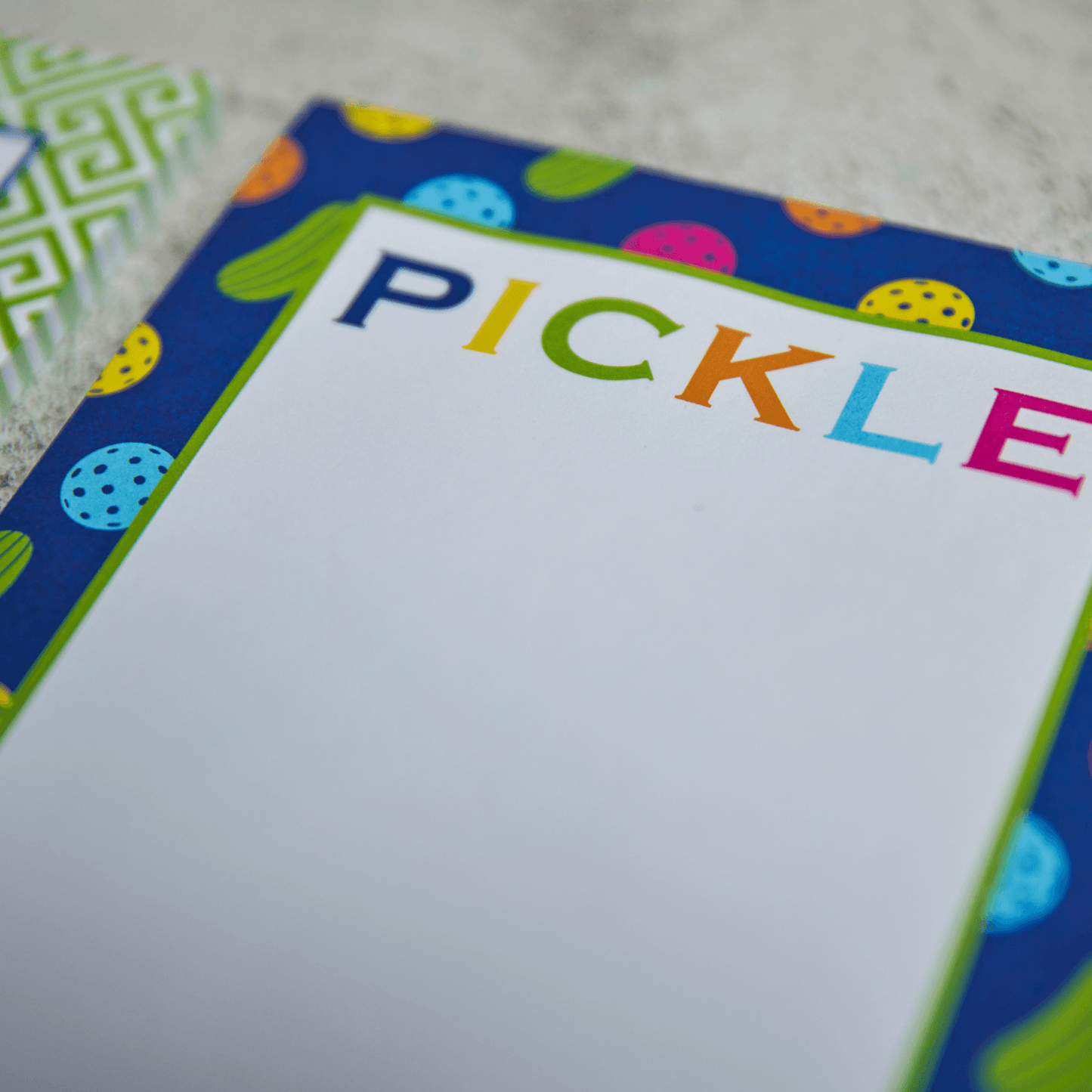 The Fresh Pickle Pickleball Notepad features a colorful paddle and ball border and "PICKLE" in bold, multicolored letters at the top. Fun and practical, it’s a great gift for any pickleball enthusiast.
