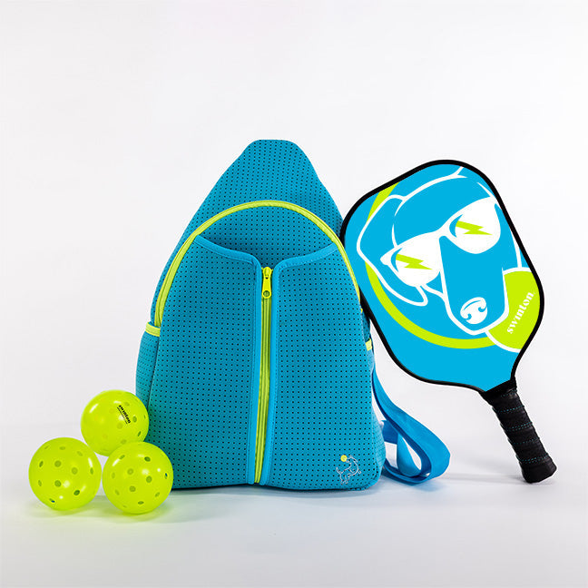 The Swinton Pickleball Starter Bundle - Blue includes a blue backpack, three neon yellow pickleballs, and a dog-face paddle with sunglasses—all set against a white background, making it the perfect pickleball gift.