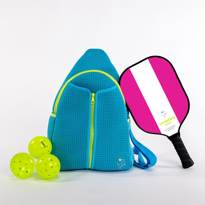 The Swinton Pickleball Starter Bundle - Blue features a bright blue backpack with yellow zippers, three neon yellow pickleballs, and a pink-and-white striped paddle with a black handle, all set on a plain white background.