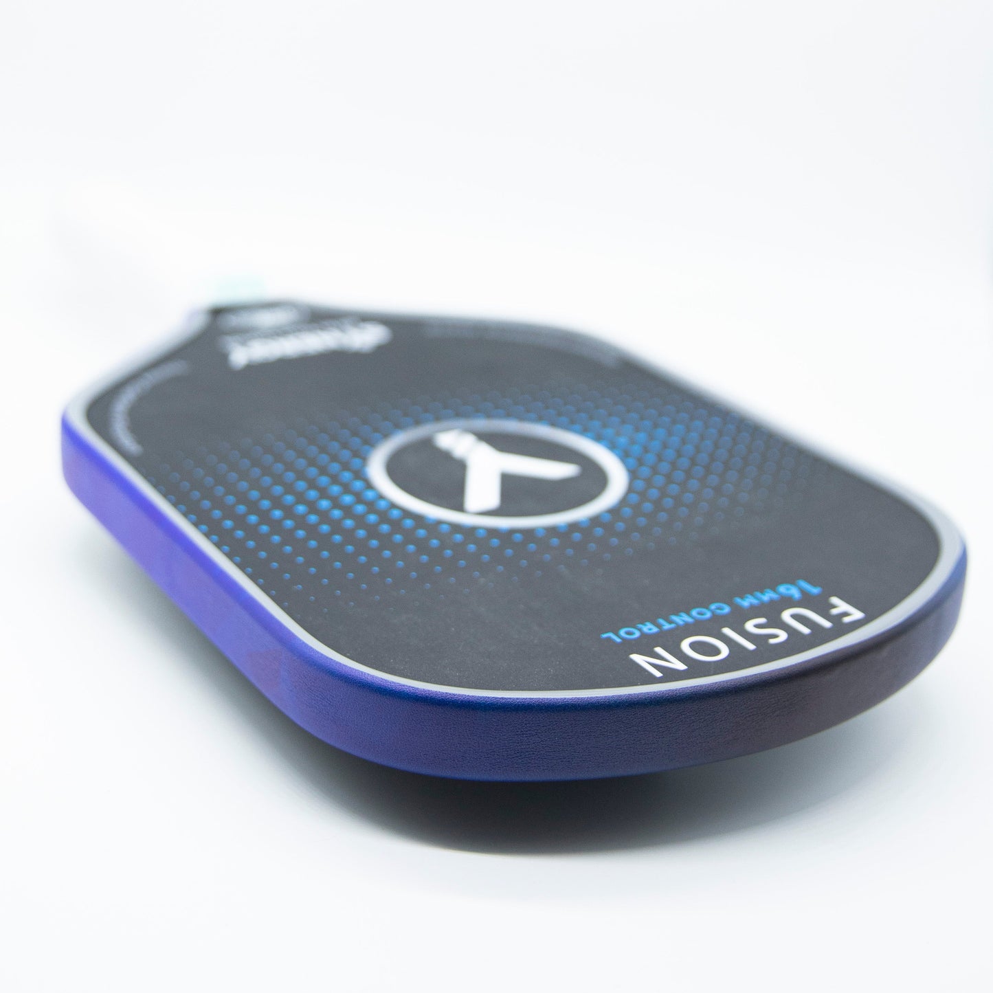 A close-up of a Bodhi Performance pickleball paddle with premium edge tape for professional edge guard protection rests on a white surface, showcasing its black and blue design with “16mm CONTROL” near the bottom and a partially blurred handle.