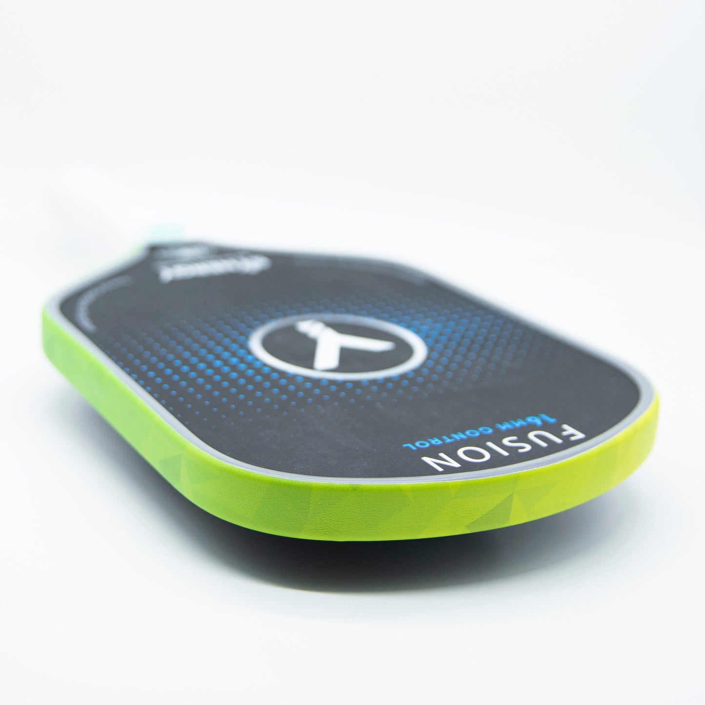 A close-up of a pickleball paddle with Bodhi Performance Premium Edge Tape in green, a dark face with blue dots, and a white Bodhi logo at the center. "FUSION" and "CONTROL" are on the lower right; handle blurred in background.