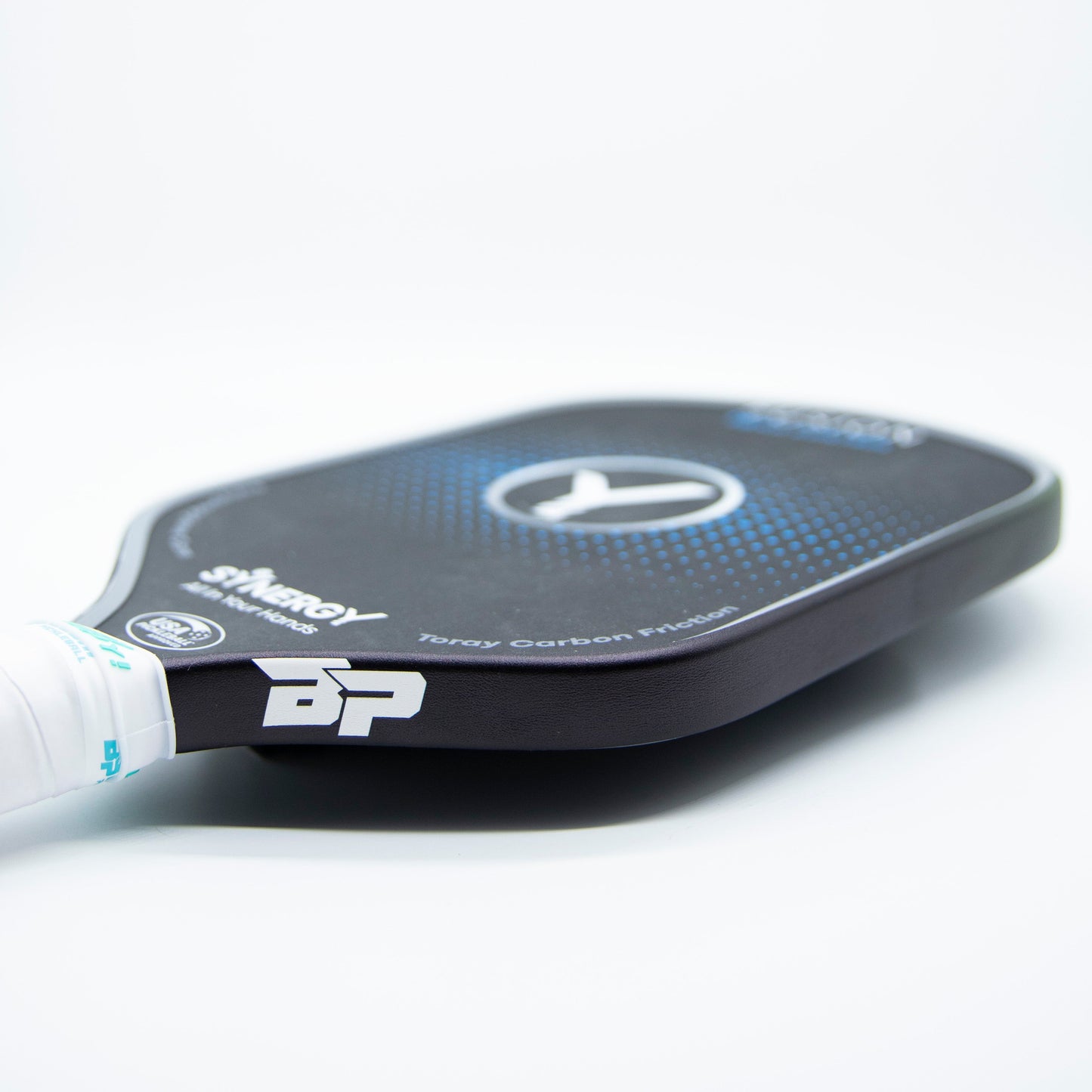 A close-up of a black Bodhi Performance pickleball paddle with a blue and white circular design, white branding, and a wrapped white handle—featuring Bodhi Performance Premium Edge Tape for professional edge guard protection—on a plain white background.