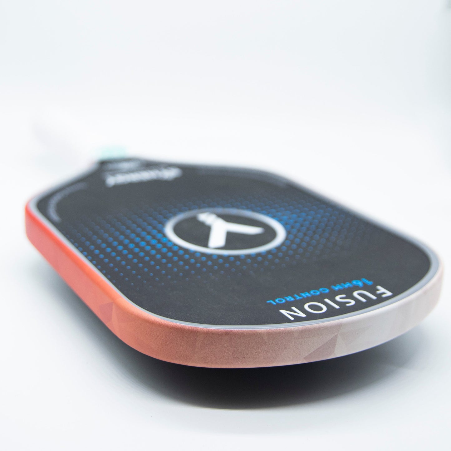 A close-up of a black Bodhi Performance pickleball paddle features premium edge tape from Bodhi Performance for professional edge guard protection, with a textured paddle face, blue accents, and a white handle blurred in the background.