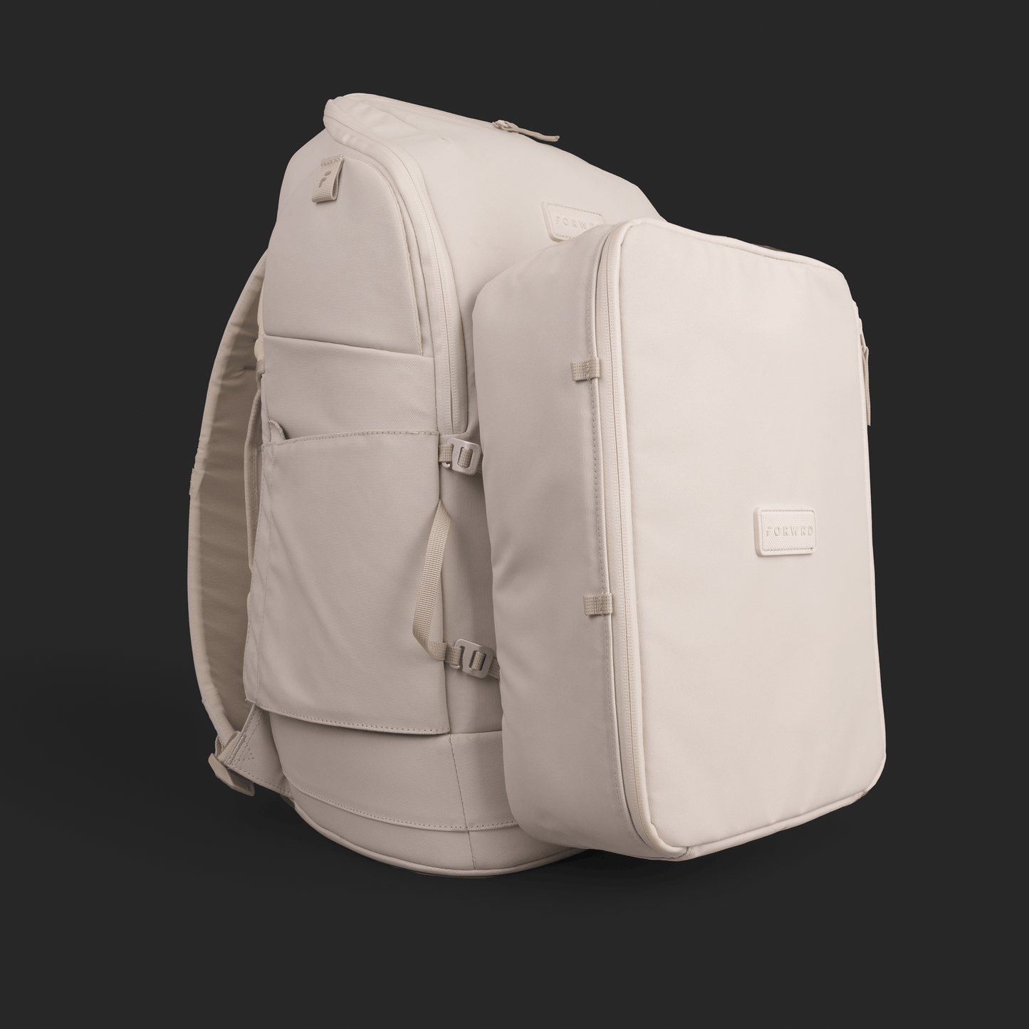 The FORWRD Court Caddy Shoe Cube, a large cream backpack with padded straps and side pockets, stands upright against a black background. A matching packing cube with a small logo patch is attached to the front for a sleek, modern look.