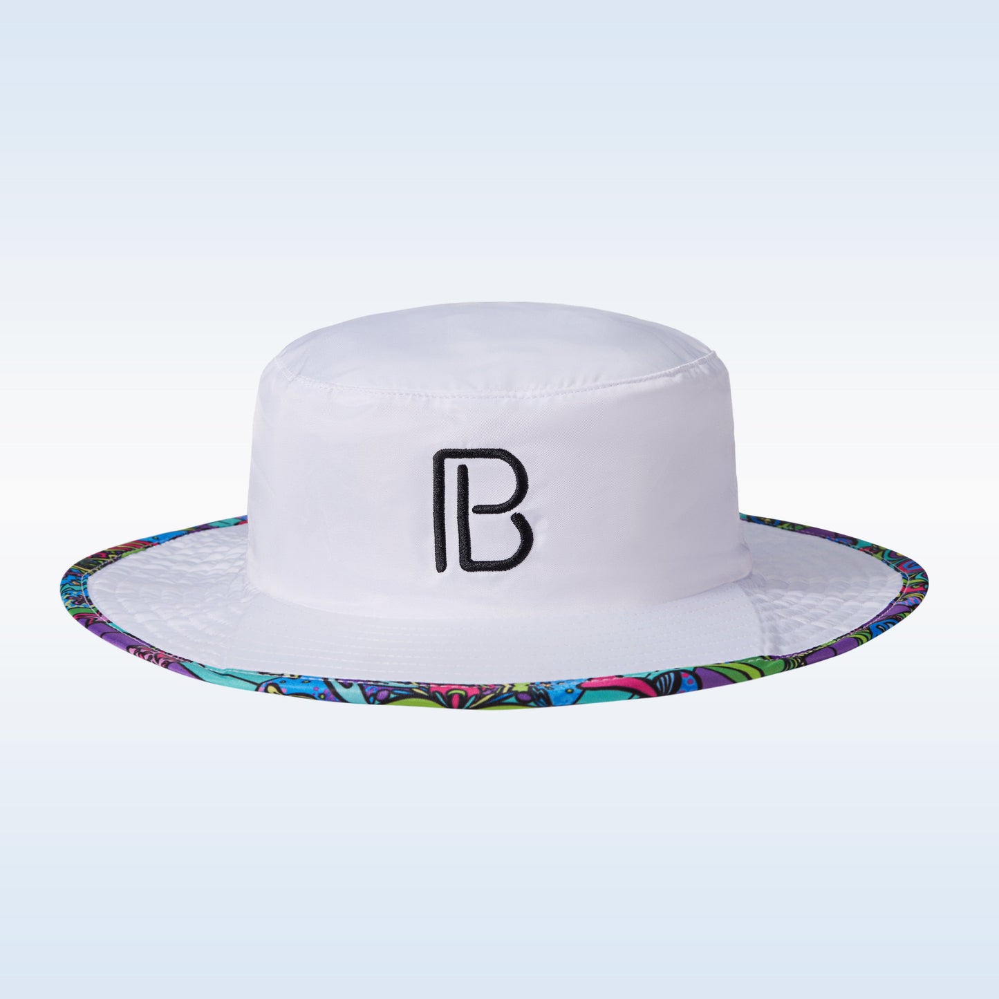 The PB Bucket Hat Groovy by Pickleball Bella is a white wide-brim bucket hat with a black “B” logo, colorful abstract trim in blue, green, and purple, and light blue gradient background—perfect for pickleball fans seeking sun protection.