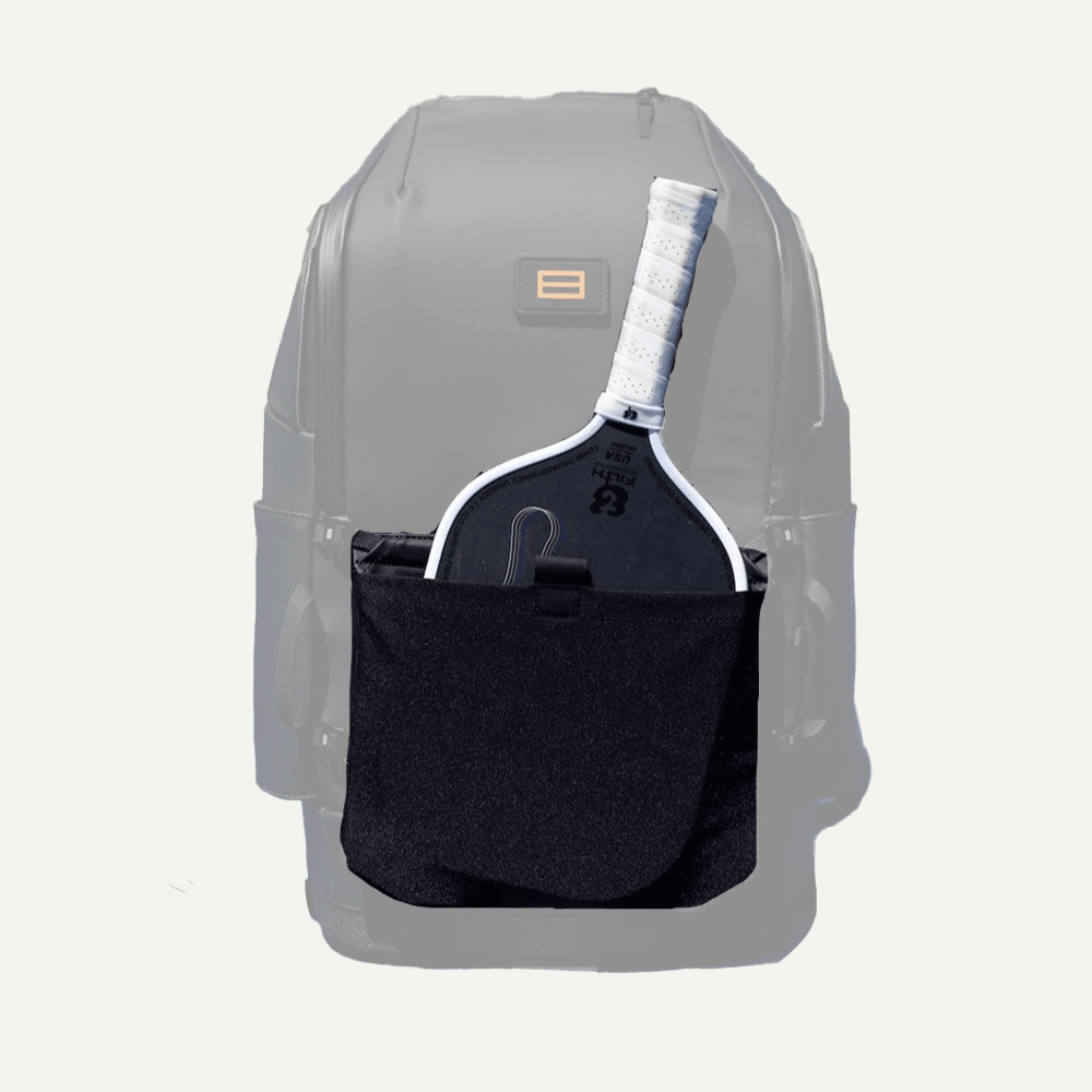 The FORWRD Court Caddy Front Paddle Sleeve, in gray and black, securely holds a black pickleball paddle with a white grip in its large front pocket. The setup is shown on a plain white background.