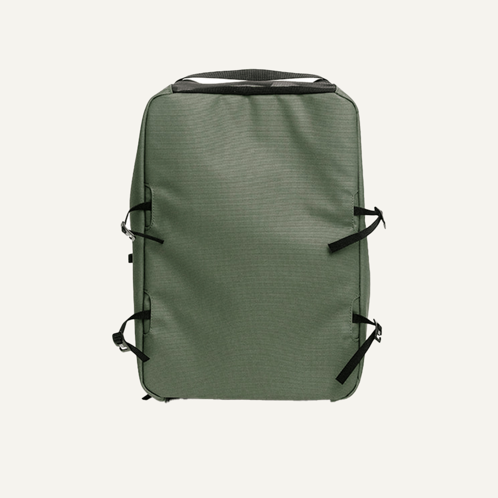 The FORWRD Court Caddy Shoe Cube in olive green has a rectangular shape, black top handle, and four black side straps—a minimalist design ideal for pairing with travel gear and keeping shoes organized against a plain background.