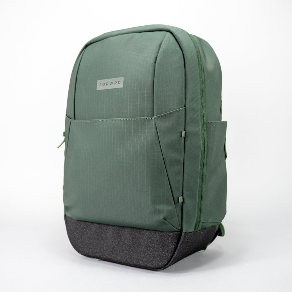The FORWRD Court Ranger Pickleball Backpack, a green minimalist bag with a black textured bottom, front and side pockets, sits upright on a white background—making it the top pickleball bag under $200 for style and functionality.