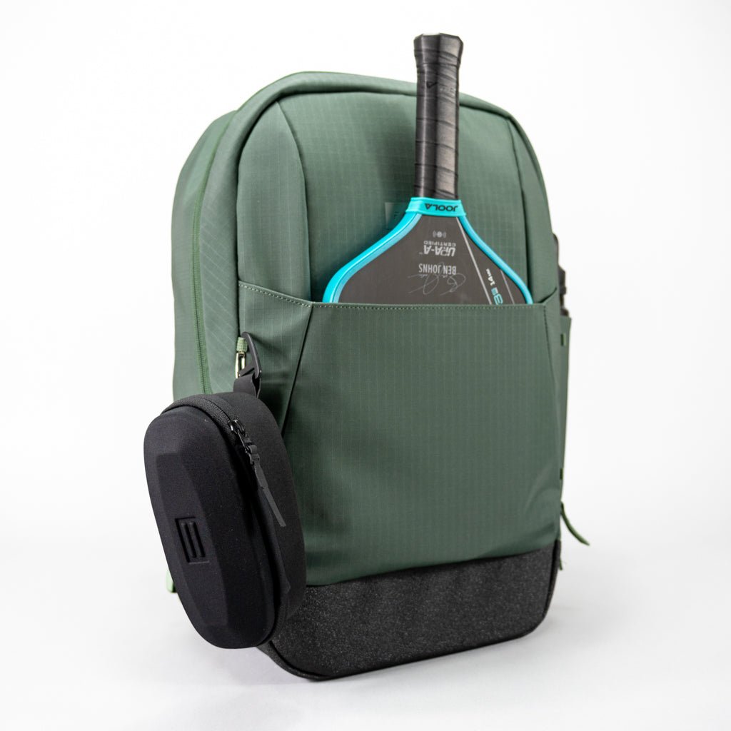The FORWRD Court Ranger Pickleball Backpack features a green design with a black base, front pocket for your teal and black paddle, and a small zippered side case—making it a top pickleball bag choice under $200. Shown on a plain white background.