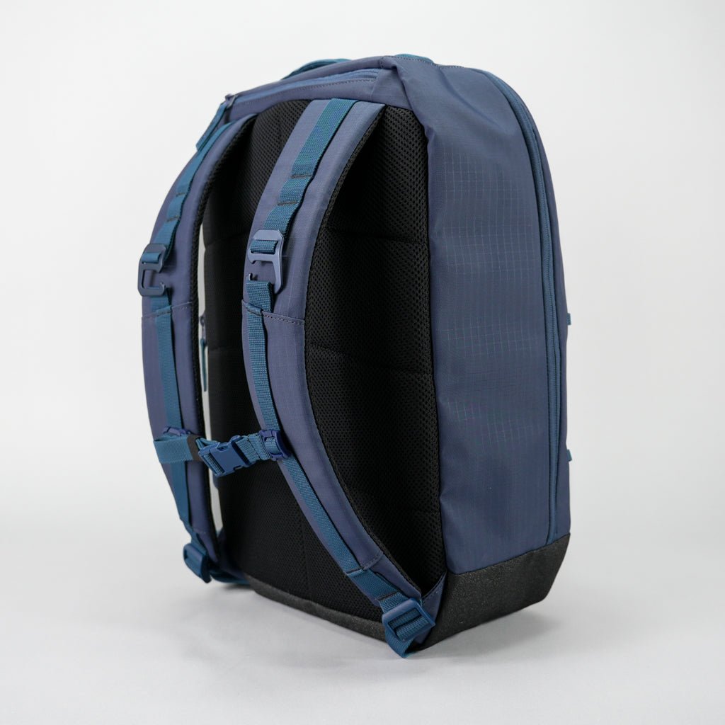 The FORWRD Court Ranger Pickleball Backpack in navy blue is displayed upright on a white background, highlighting its padded shoulder straps, chest strap, and cushioned black back panel for comfort in a sleek, modern design with minimal visible pockets.