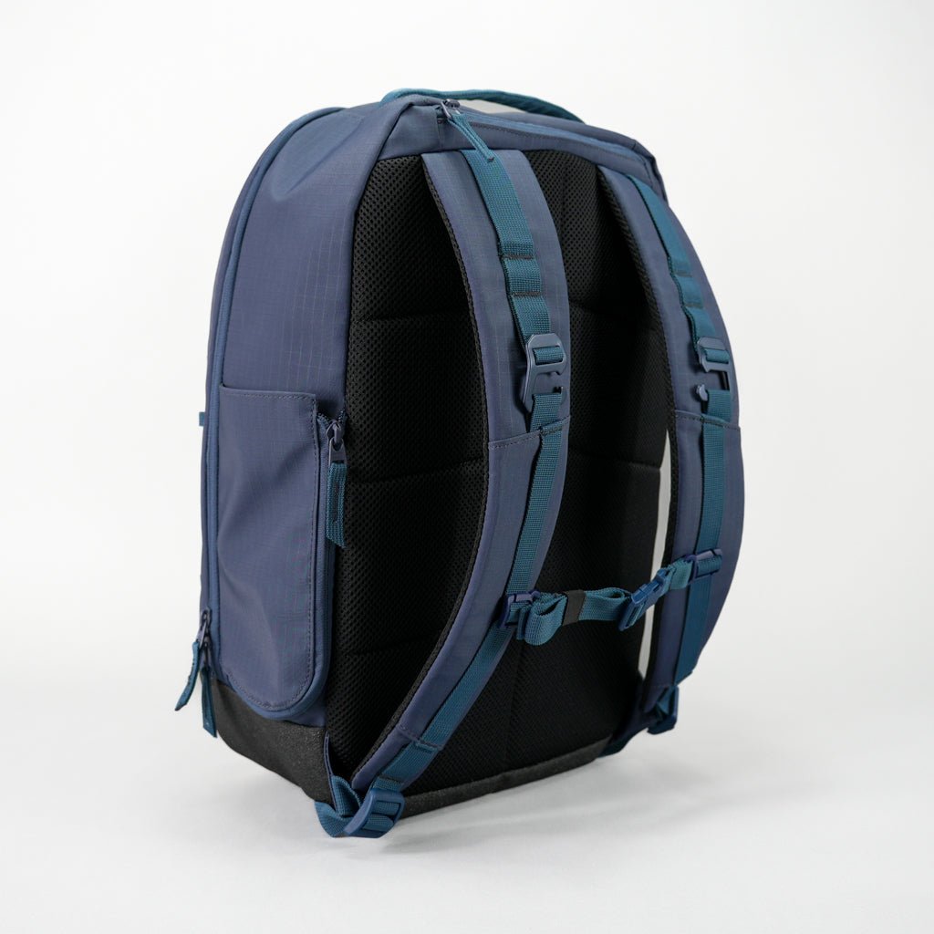 The FORWRD Court Ranger Pickleball Backpack is shown upright on a white background, featuring dark blue color, padded adjustable shoulder straps, a sternum strap, black cushioned back panel, and side pockets on both sides.