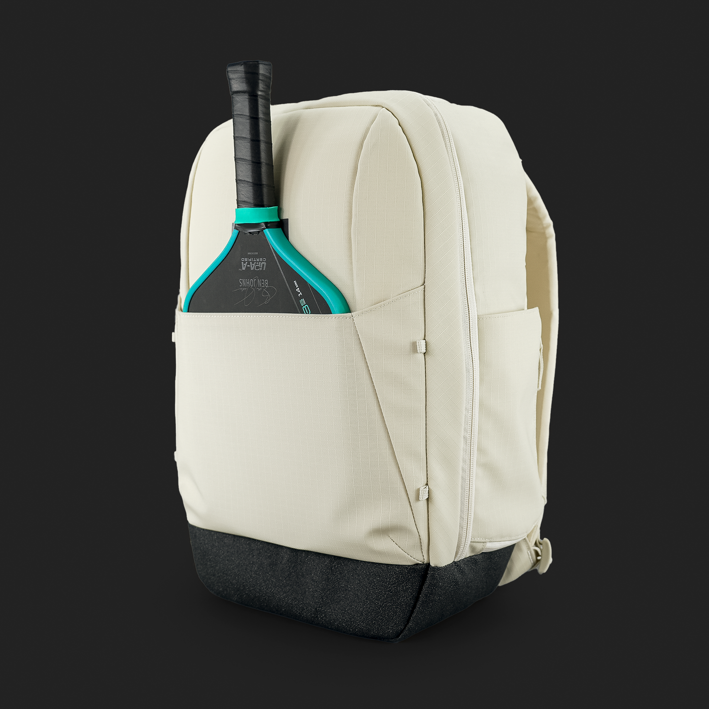 The FORWRD Court Ranger Pickleball Backpack in cream with a black base is displayed against a dark background, featuring a teal and black paddle in the side pocket—an ideal modern, structured pickleball bag.