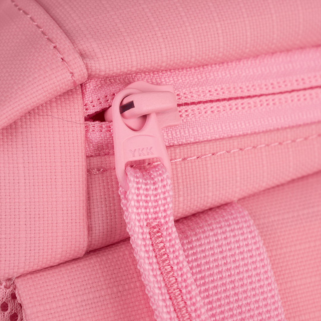 Close-up of a pink fabric zipper on the FORWRD Court Ranger Pickleball Backpack. The YKK-marked pull and matching strap stand out, while detailed stitching highlights the bag’s neat construction and uniform color.