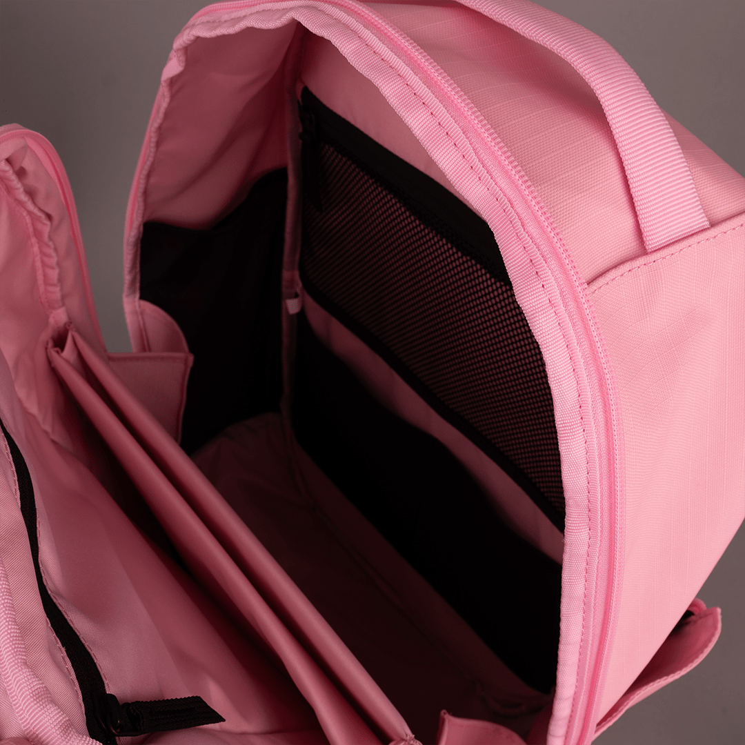 The FORWRD Court Ranger Pickleball Backpack in pink is open, revealing a spacious main compartment with a mesh pocket and divider. Smooth fabric and visible zippers showcase its organization—making it the best pickleball bag for players.