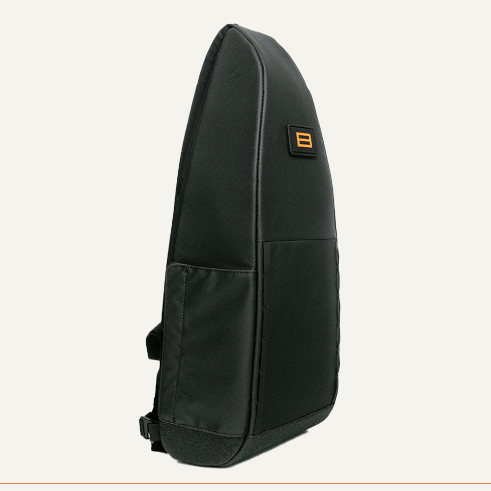 The FORWRD Cross Court Pickleball Sling is a sleek, black teardrop backpack with a minimalist design, lightweight durable material, side pocket, adjustable strap, and an orange and black logo patch on the front.