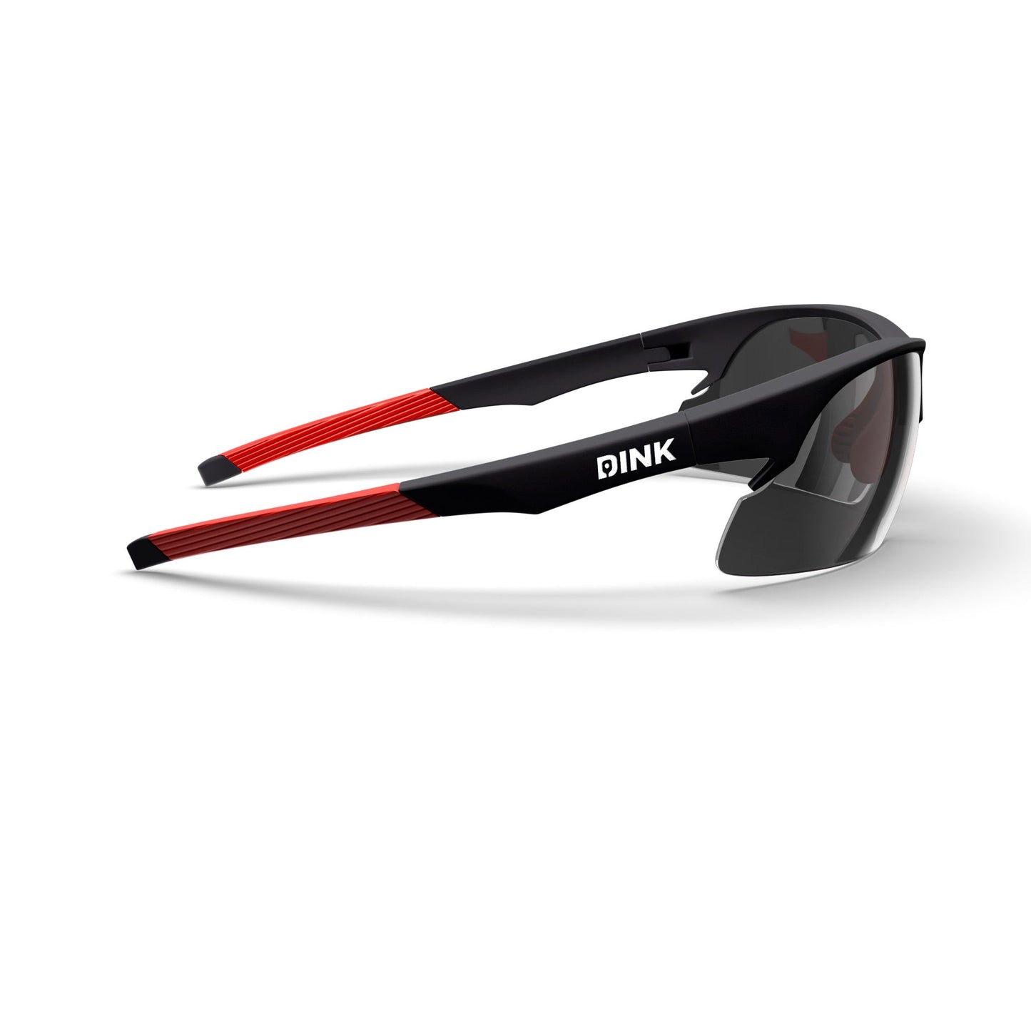Daytona Sunglasses by Dink Eyewear feature black frames, bold red arms, and a white DINK logo. Their sporty wrap design, lightweight frame, and dark gray tinted lenses create a modern, aerodynamic look.