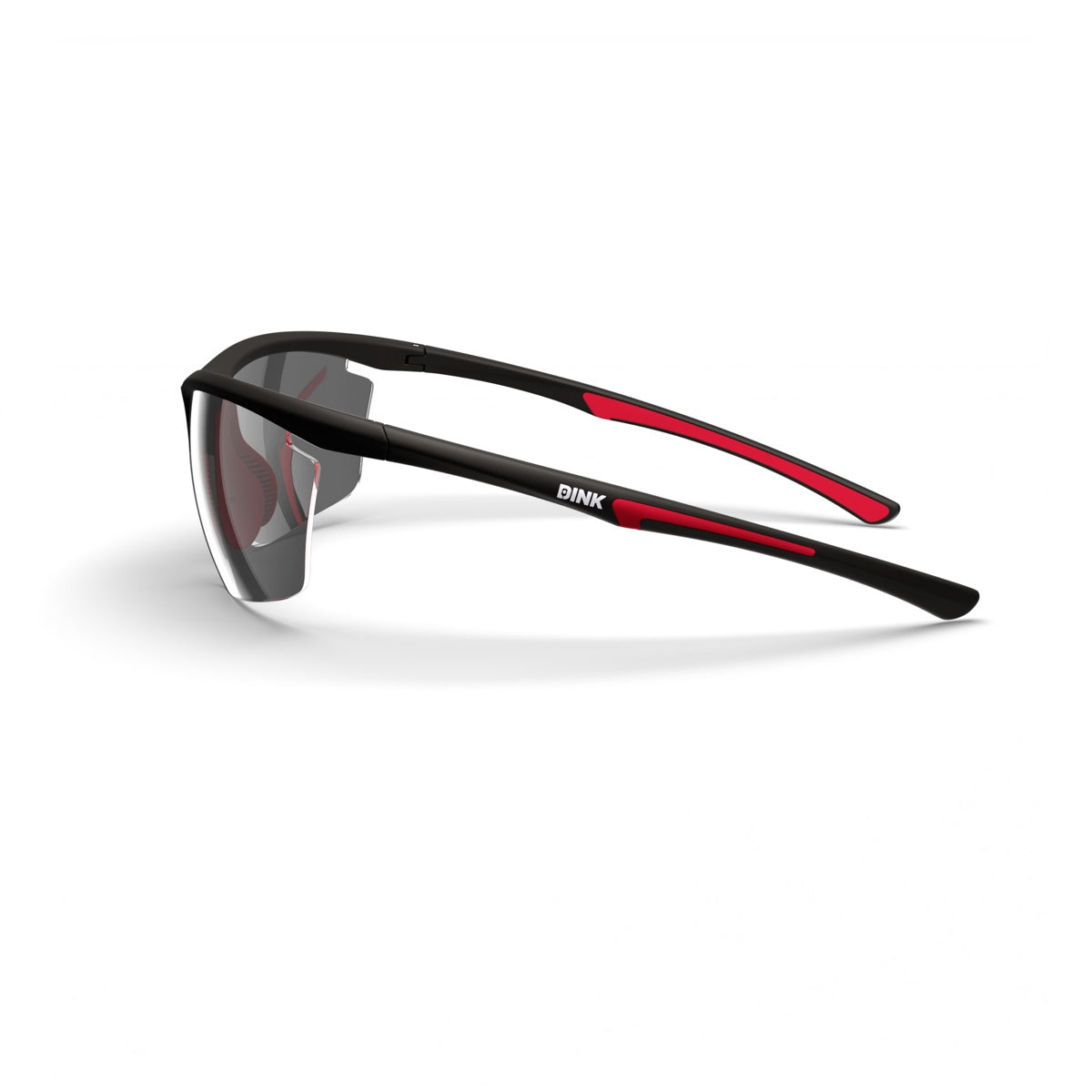 The Daytona Petite Pickleball Sunglasses by Dink Eyewear feature black lightweight frames, red temple accents, and semi-rimless tinted lenses. “DINK” appears in white on the left temple. Shown angled on a white background.