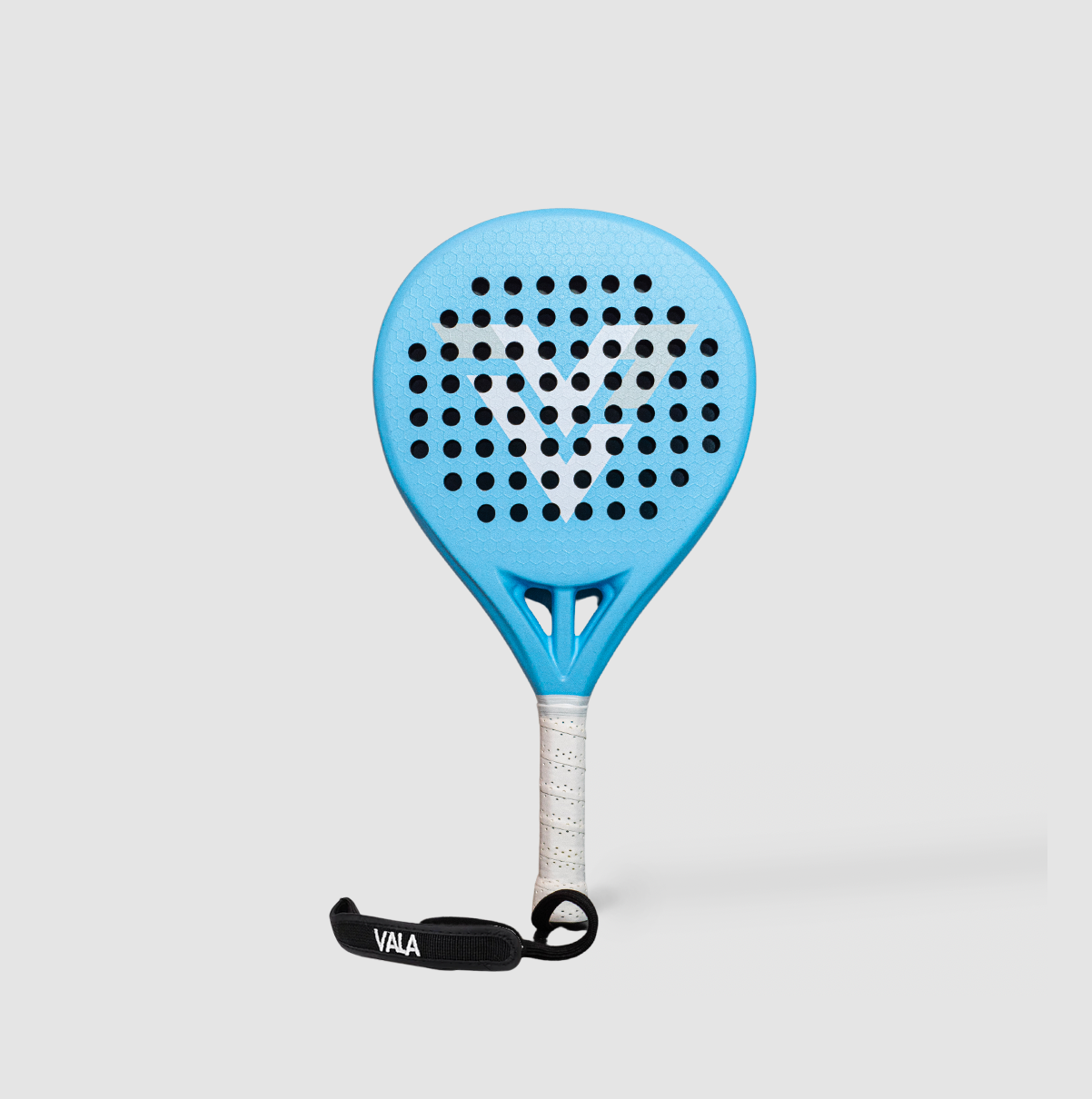 The VALA One (Junior Edition) by VALA is a blue kids' padel racket with a white grip, black wrist strap labeled VALA, and round holes forming a large white V on the face. Set against a plain light gray background.
