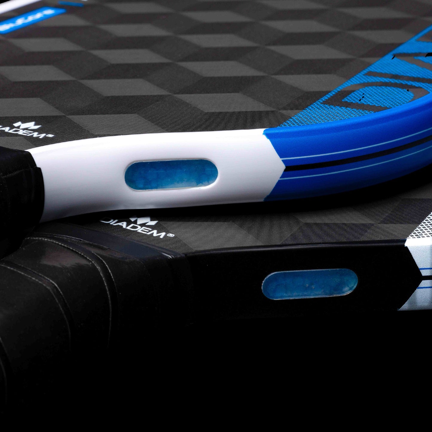 Close-up of two Diadem Sports Edge BluCore Hybrid paddles with textured surfaces, blue grip accents, and oval transparent inserts. The Diadem logo and PowerSync BluCore Technology are visible in the USAPA-approved design.