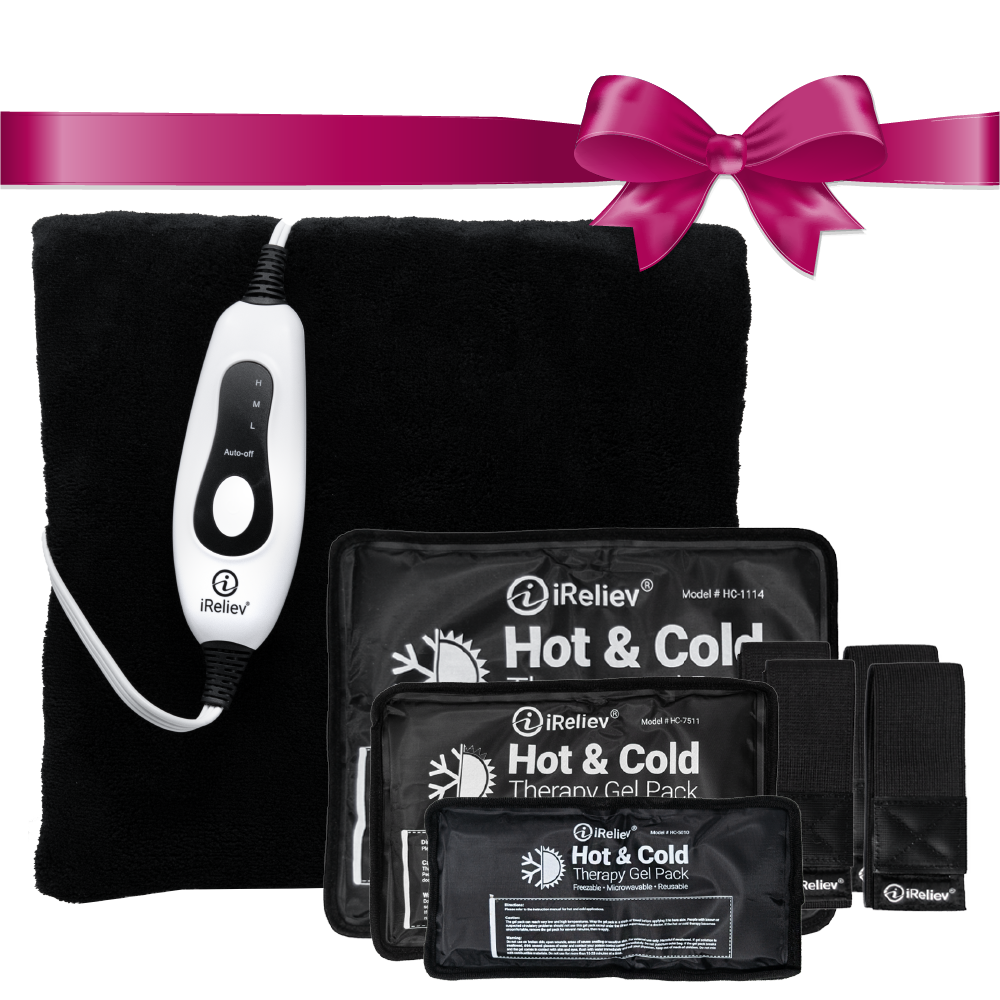 The iReliev Hot and Cold Bundle includes a black heating pad with white controller, three hot/cold packs in various sizes, two black straps, and a pink bow—all neatly arranged for convenient pain relief.