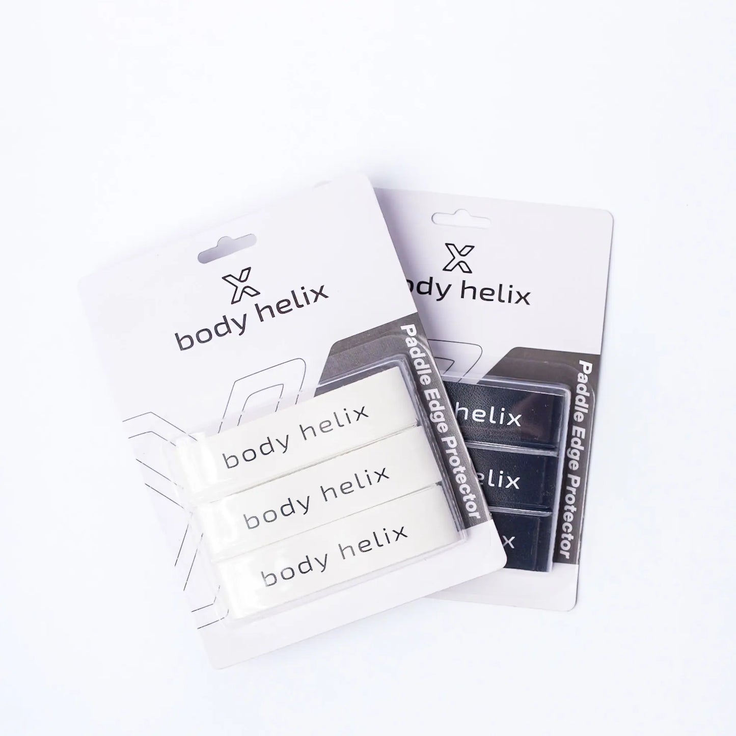 Shown are two packages of body helix Pickleball Edge Guard Tape, each with three edge protection strips—one set in white, one in black—to protect your pickleball paddle. Packaging displays the body helix brand and product name.