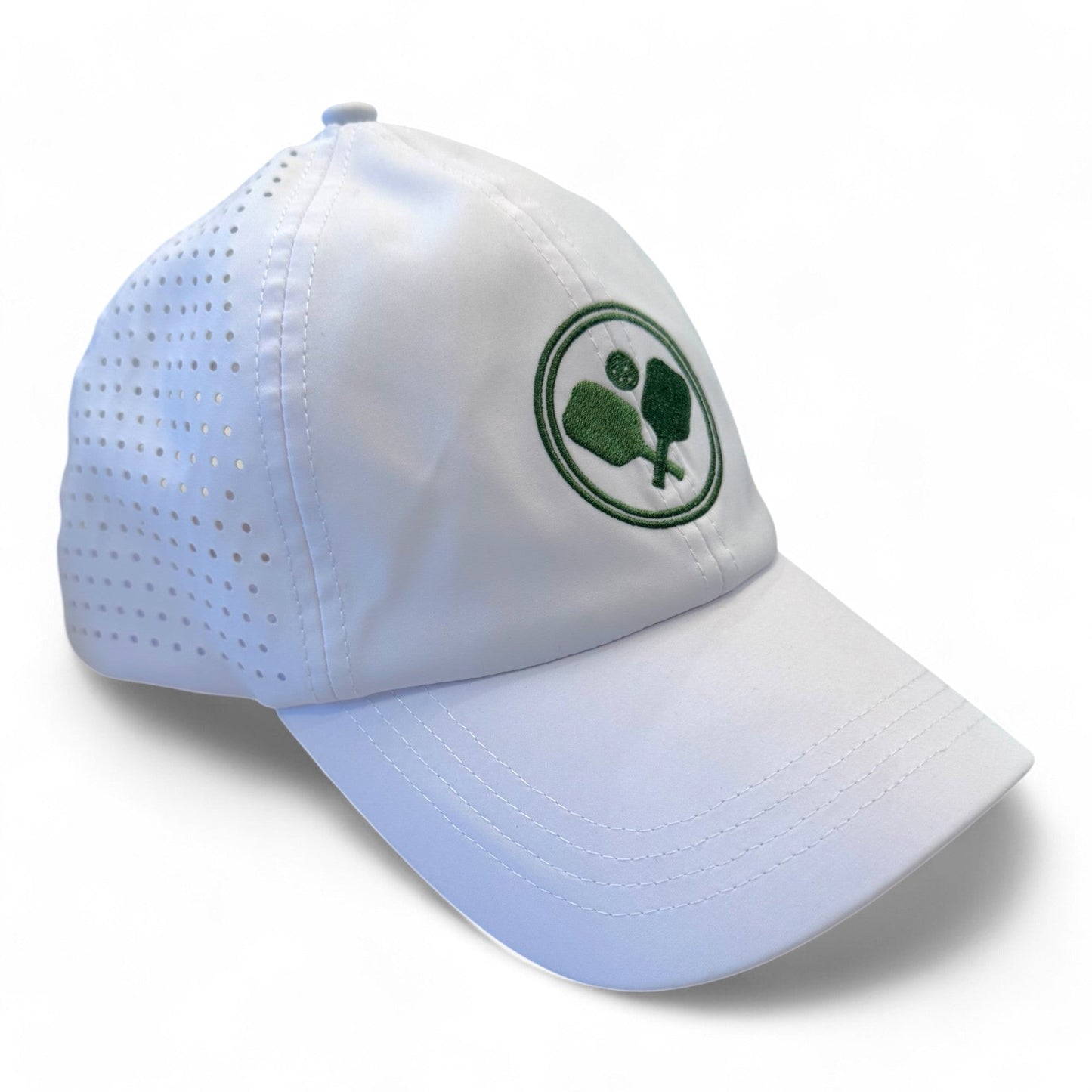 The Fresh Pickle Pickleball Cap is a breathable white sports cap with perforated side panels and a green embroidered pickleball logo of crossed paddles and a ball on the front, circled by a green border.