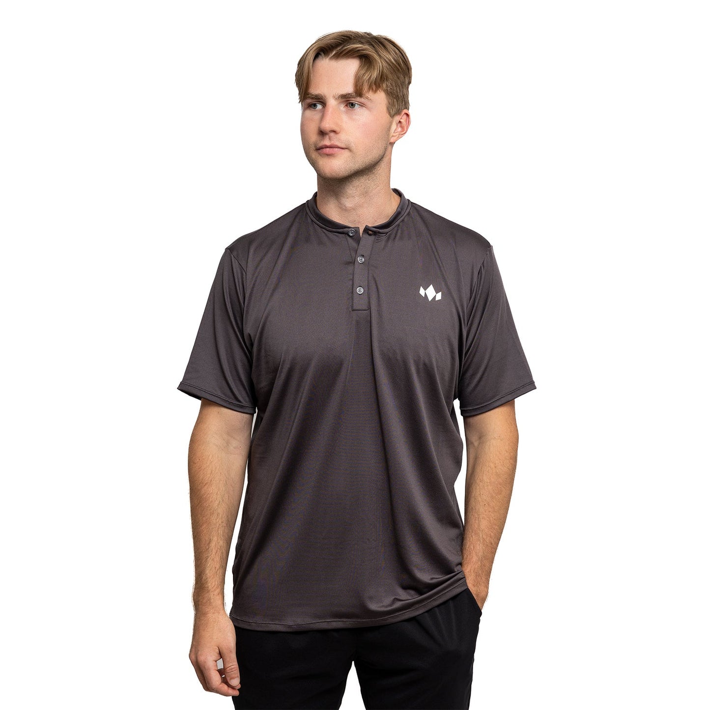 A young man with light brown hair models the Diadem Sports Men's Essential Henley, a dark gray, short-sleeve athletic-fit shirt with a small white logo on the left chest. He poses thoughtfully against a plain white background.